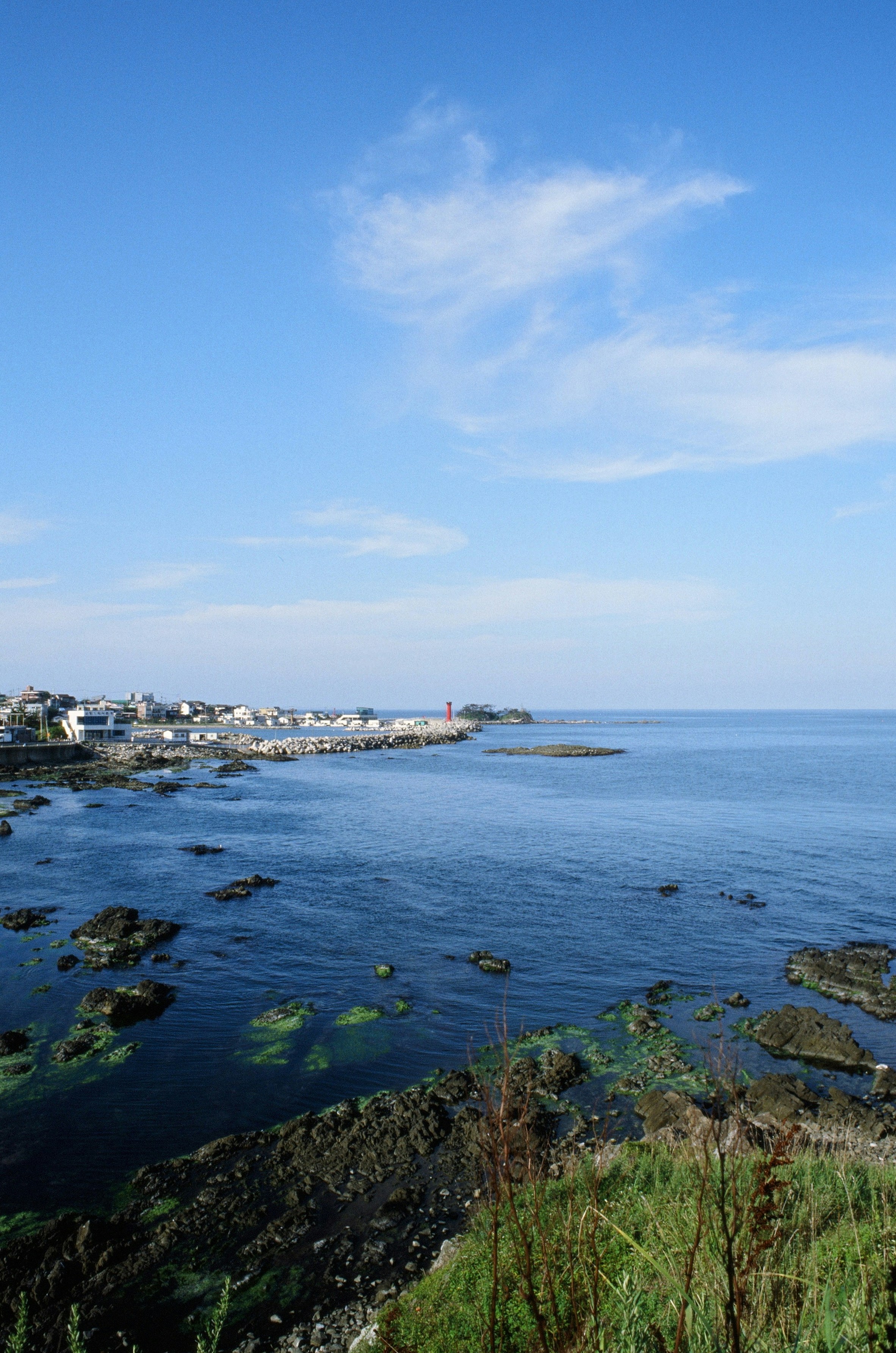 Coastal town with rocky shore and calm blue ocean