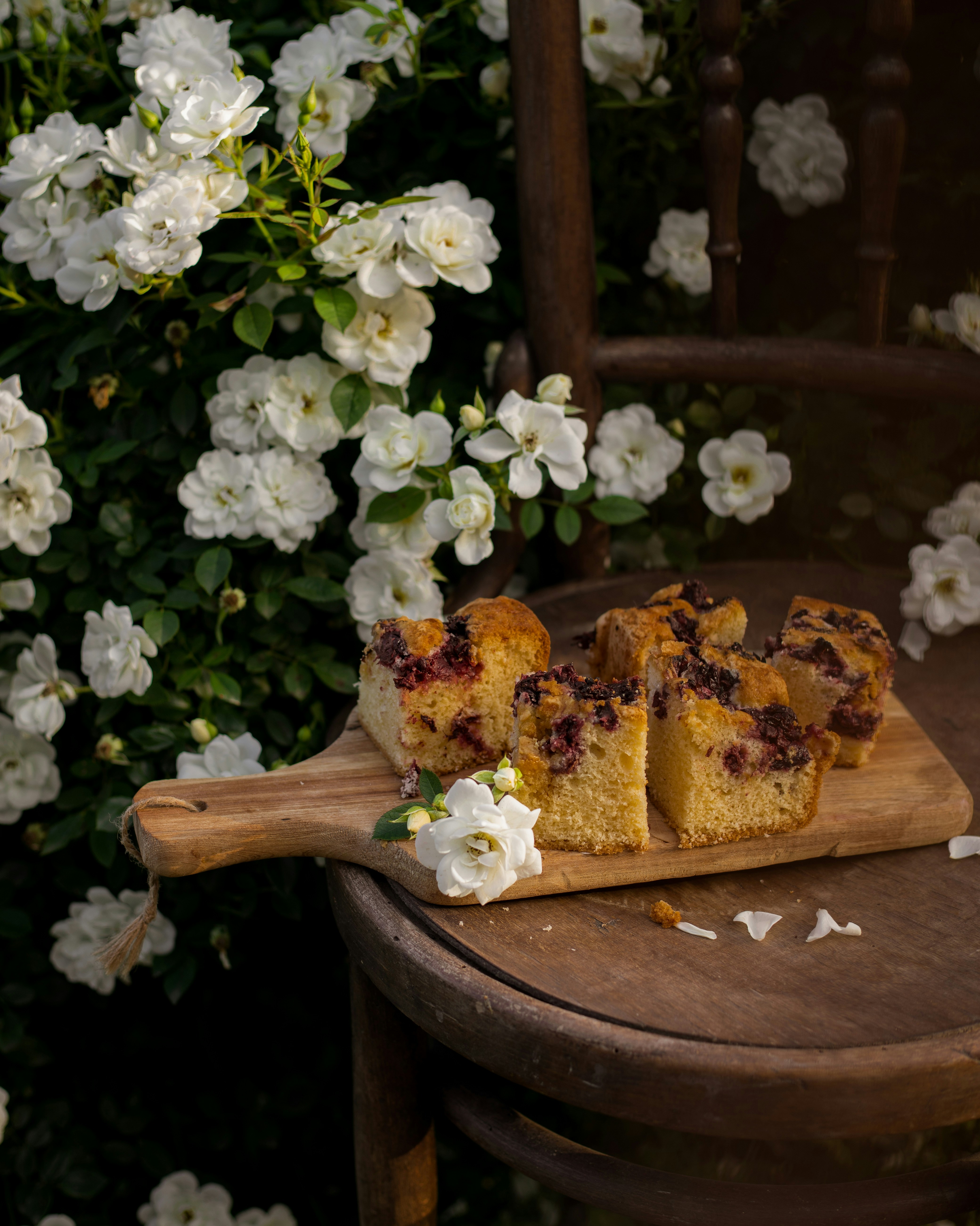 Fette di torta ai frutti di bosco su una tavola di legno con rose.
