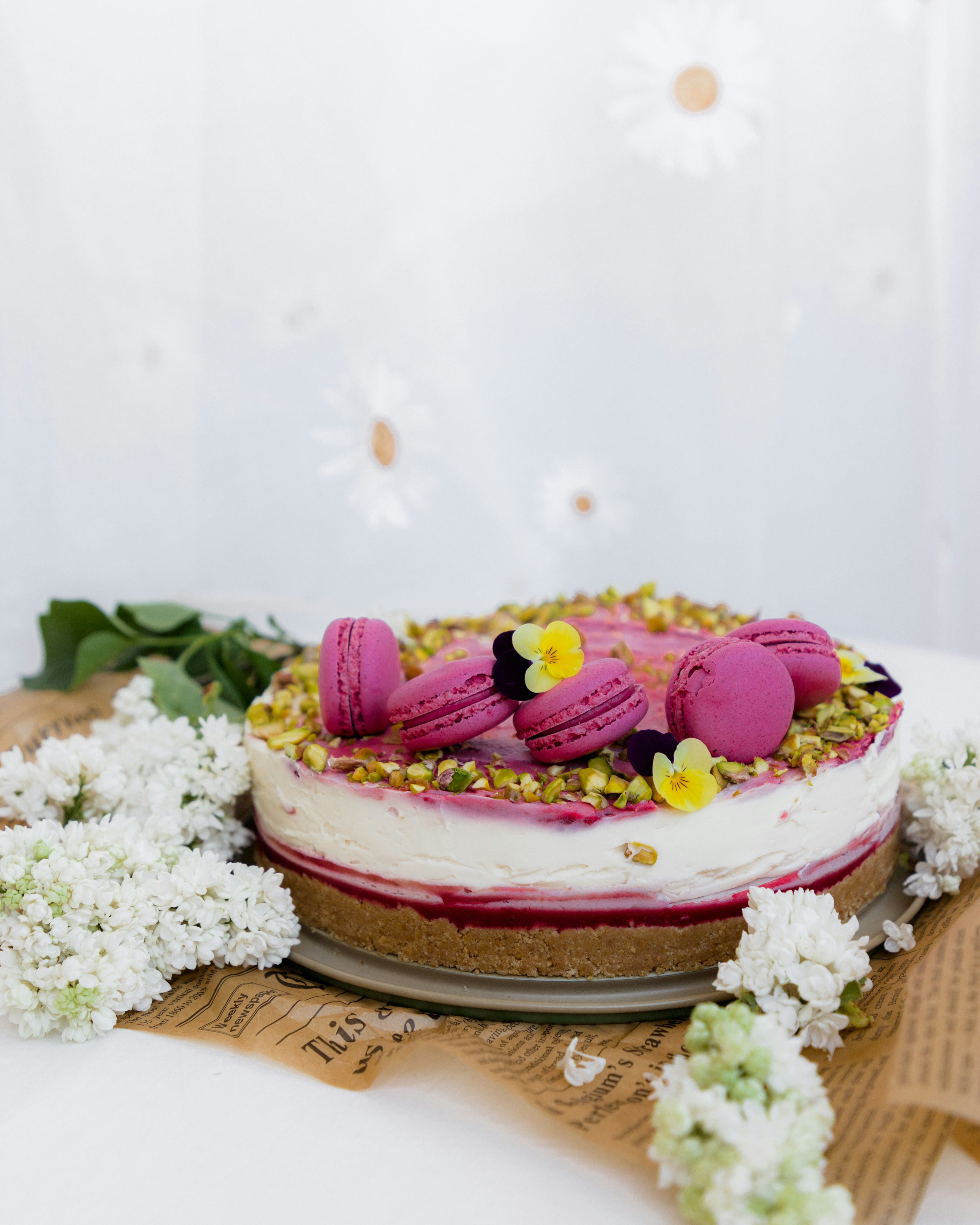 Una torta colorata decorata con macarons e fiori.