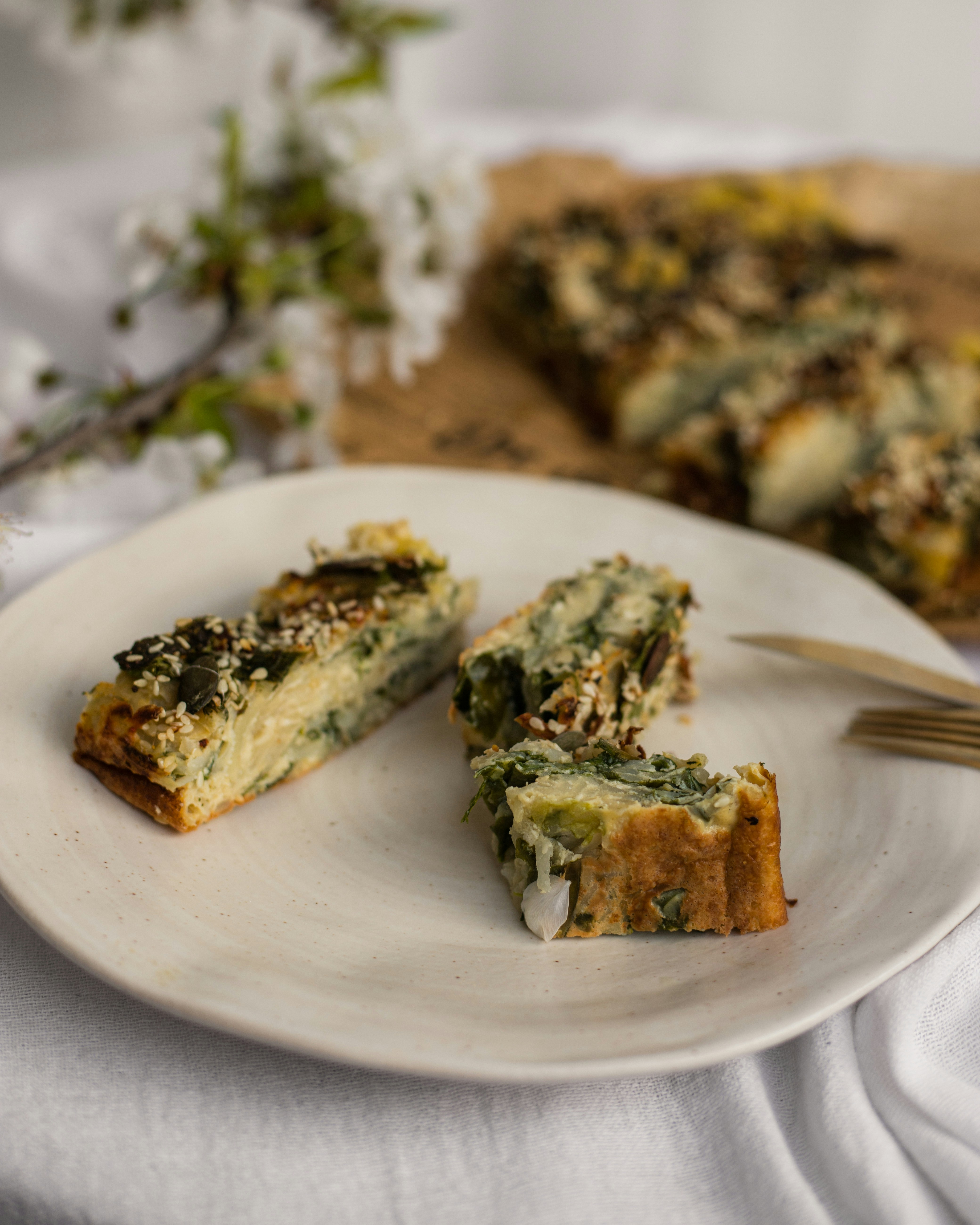 Fette di crostata di verdure salate su un piatto bianco.