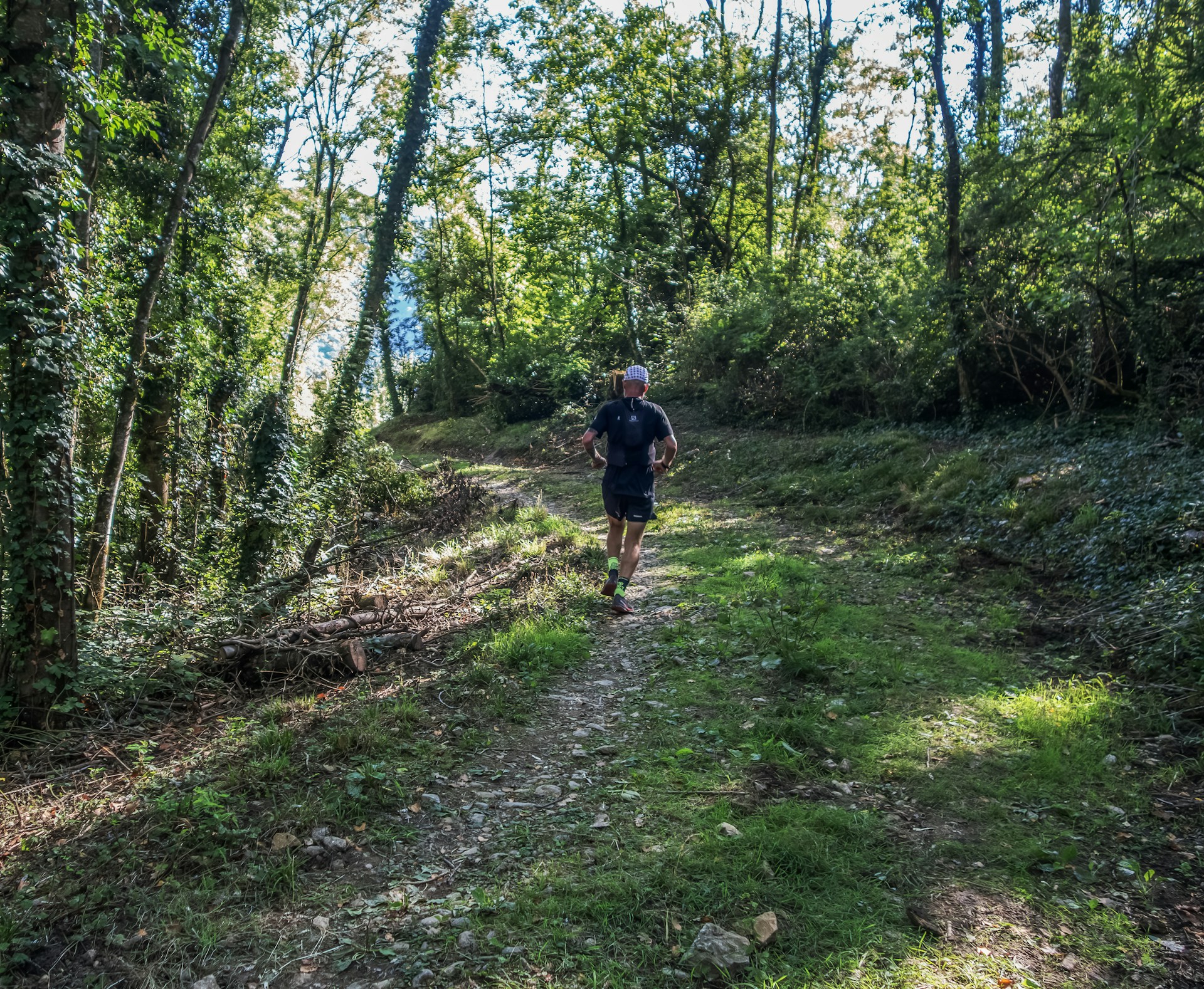 Man running on a forest path during the day