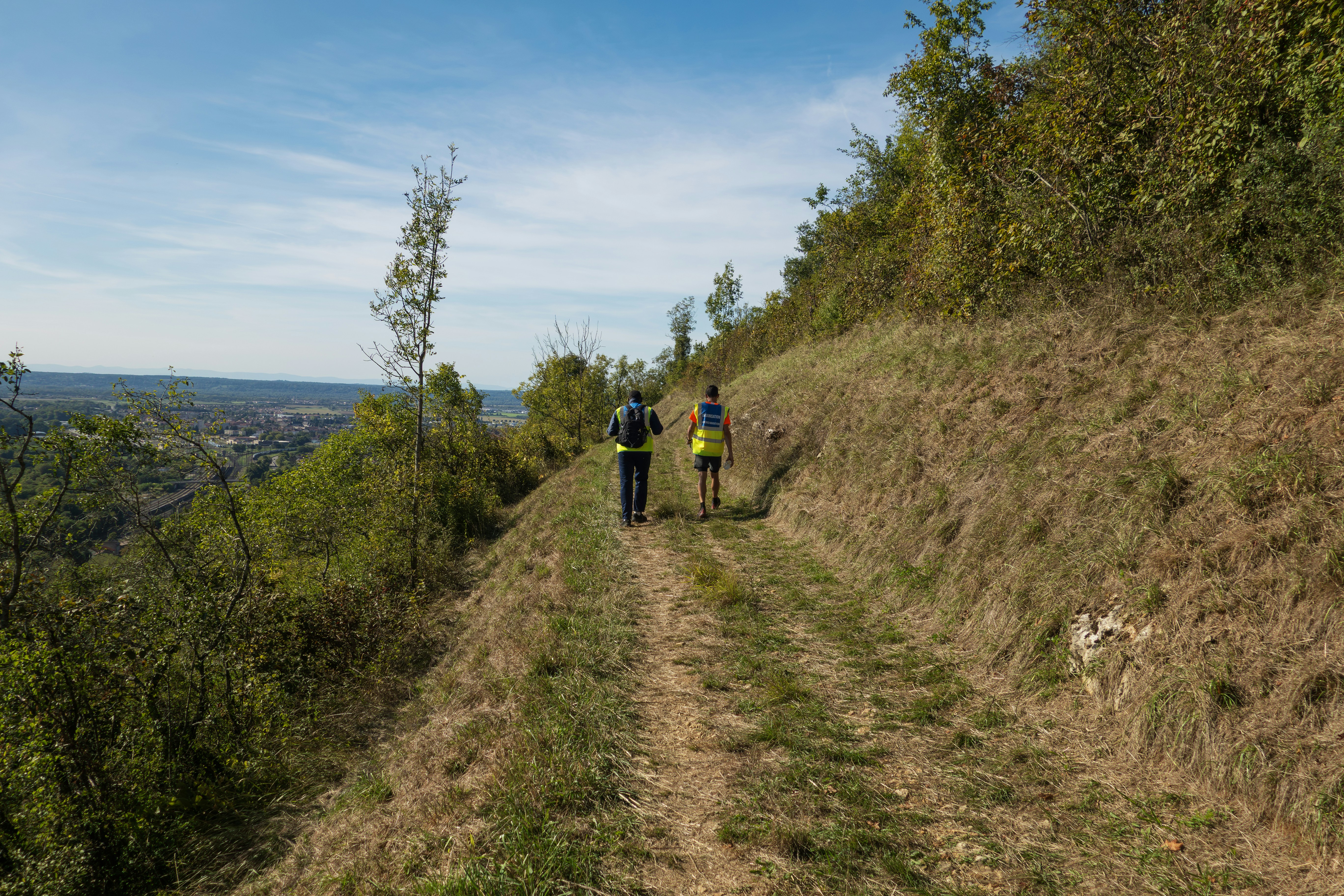 Two people hiking on a grassy trail