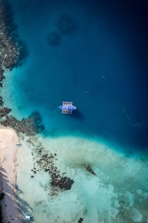 Aerial view of a boat near a tropical island shore.
