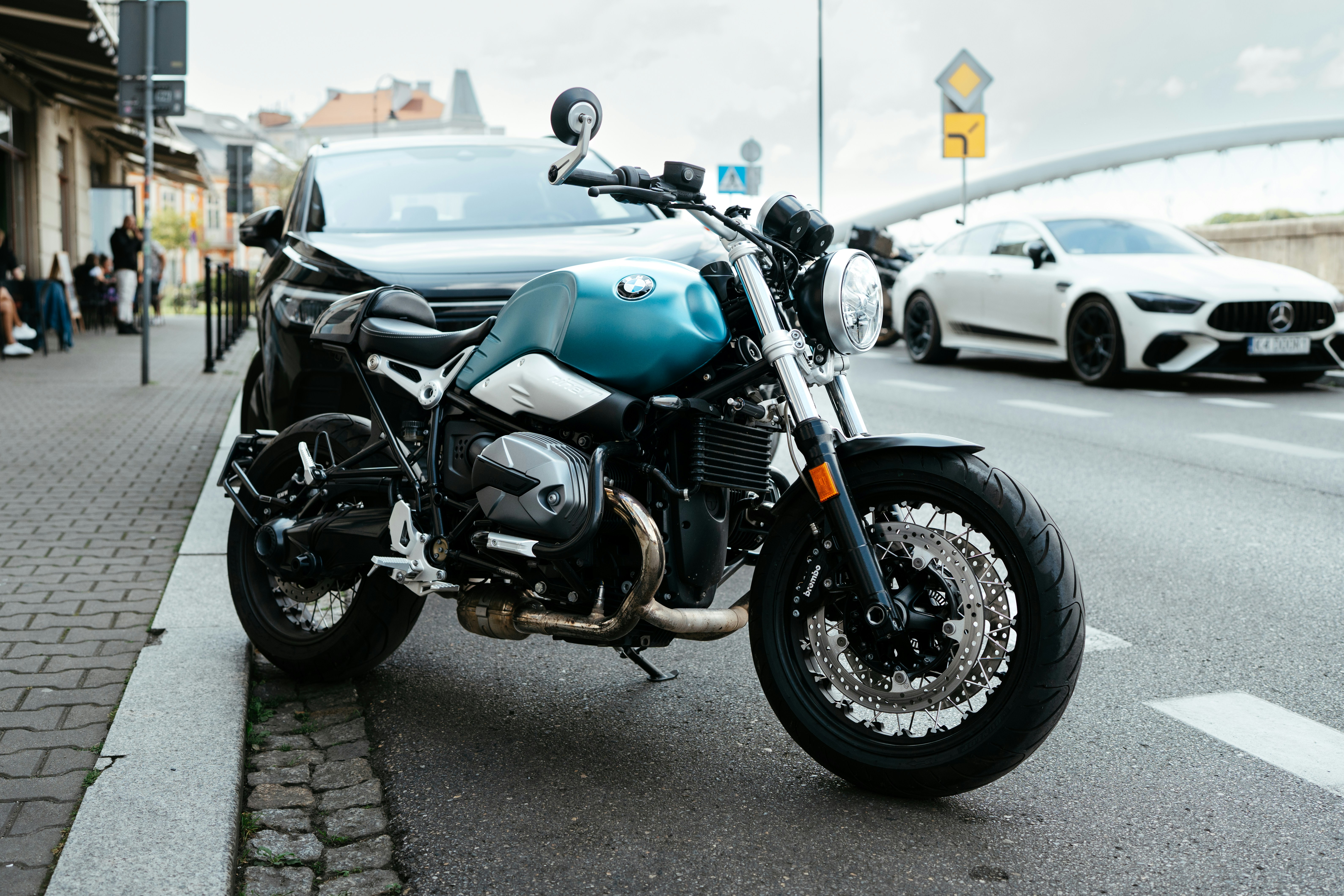 A blue and silver motorcycle parked on a wet street.