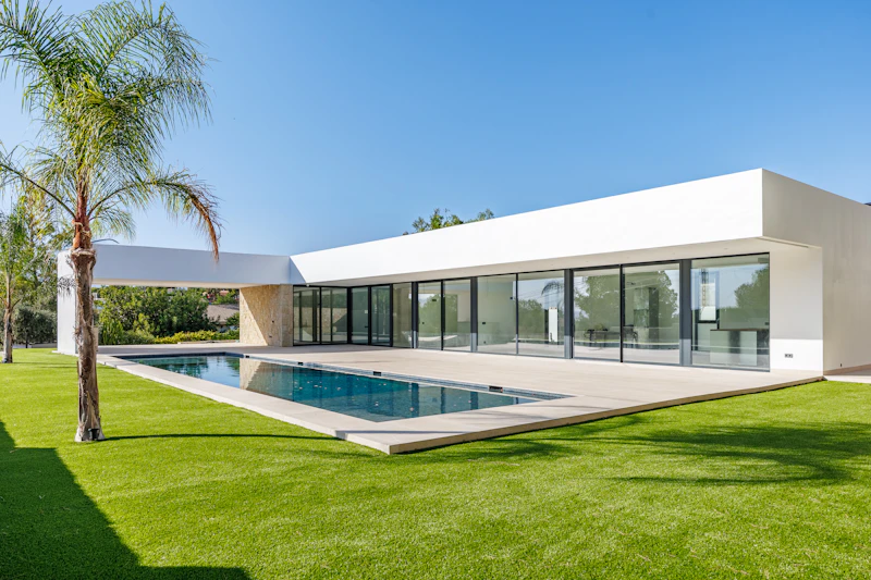 Mediterranean style villa exterior with swimming pool and palm trees