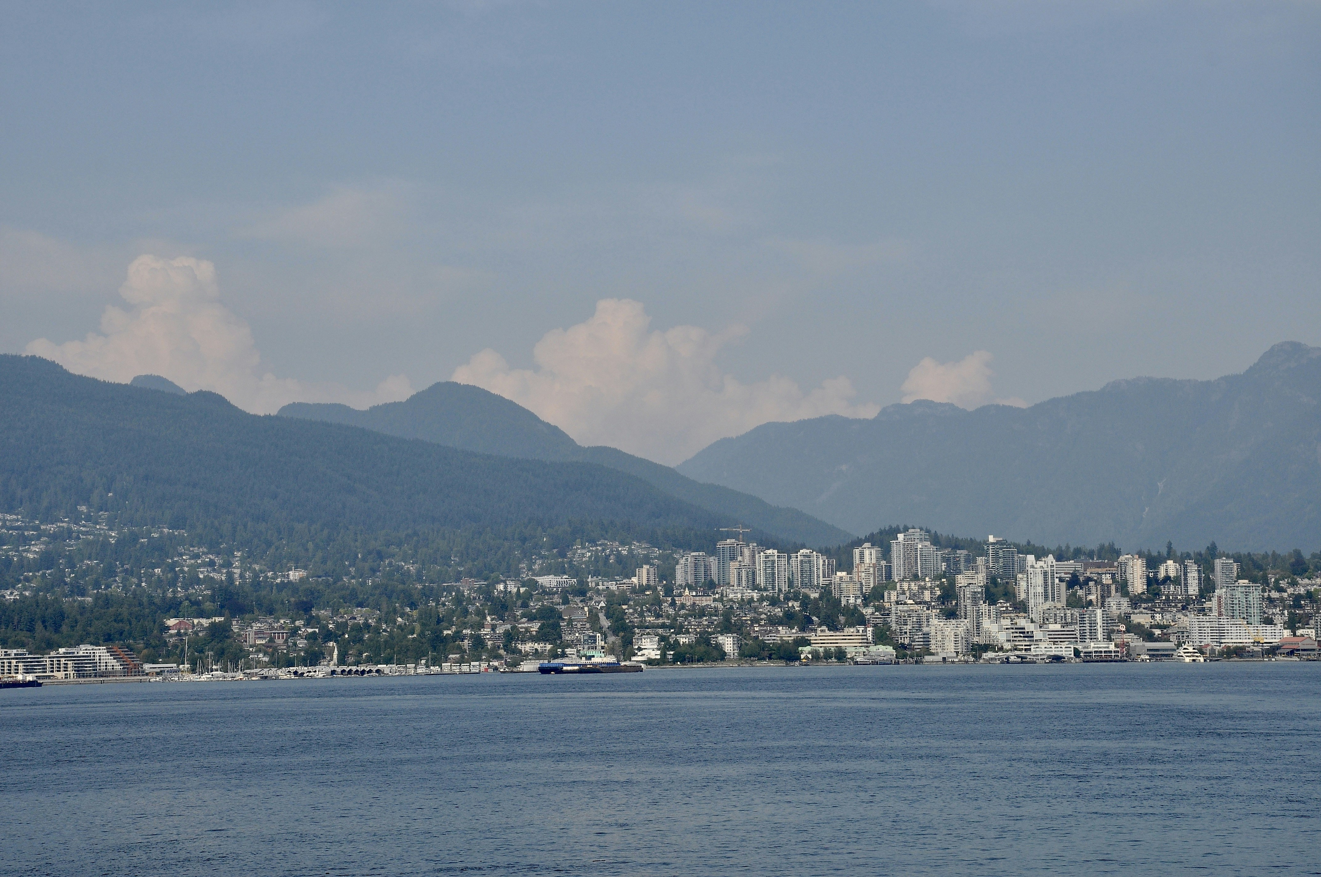 Vancouver's Stanley Park Seawall with the city and mountains in the background - best city to travel to in canada