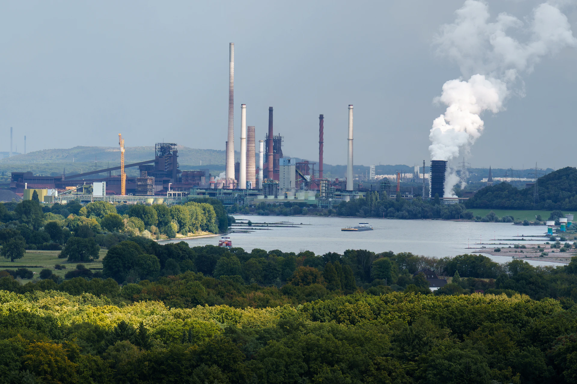 Industrial complex with smokestacks near a body of water