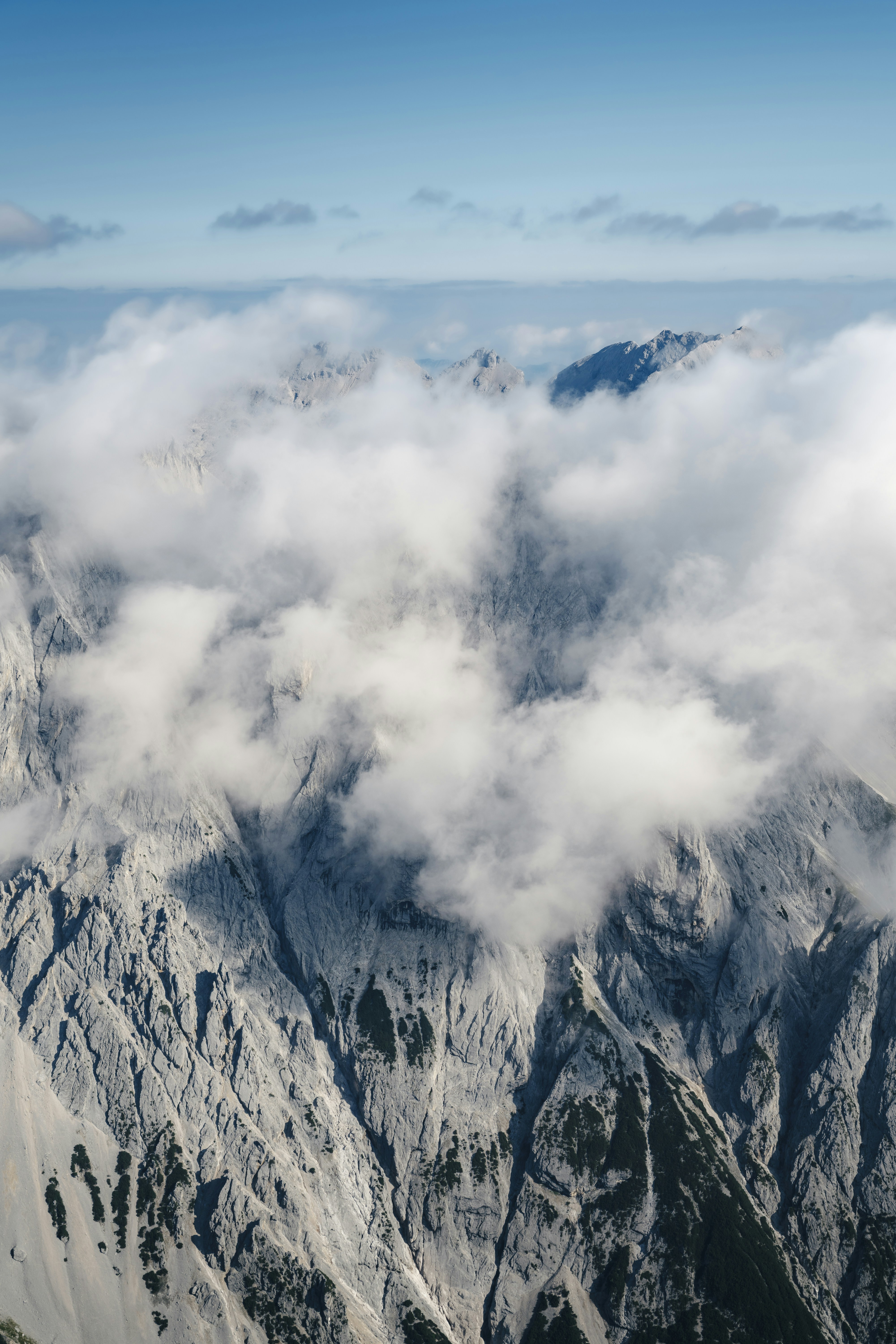 Rugged mountain peaks emerging from soft clouds