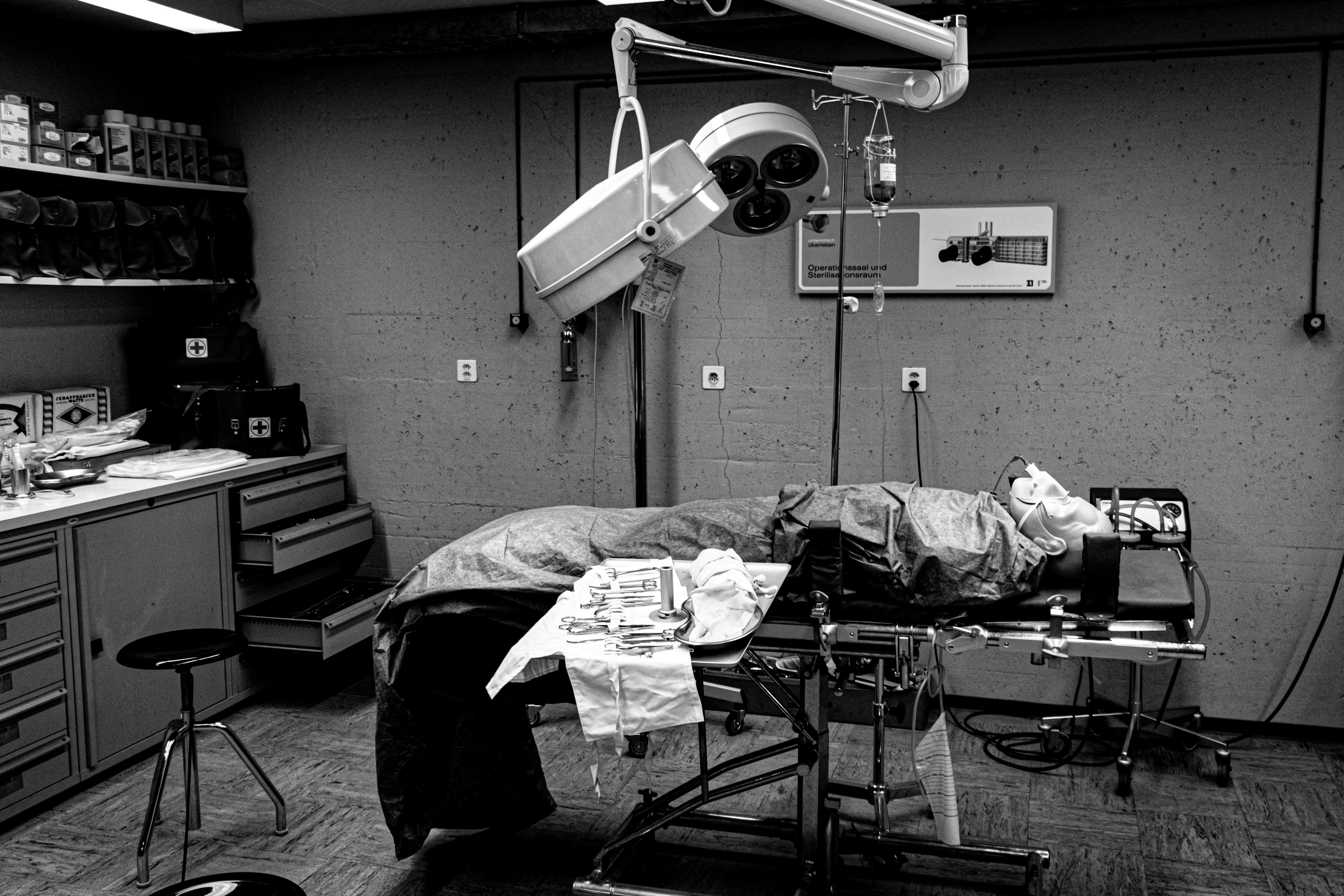 A patient lies on an operating table under surgical lights.