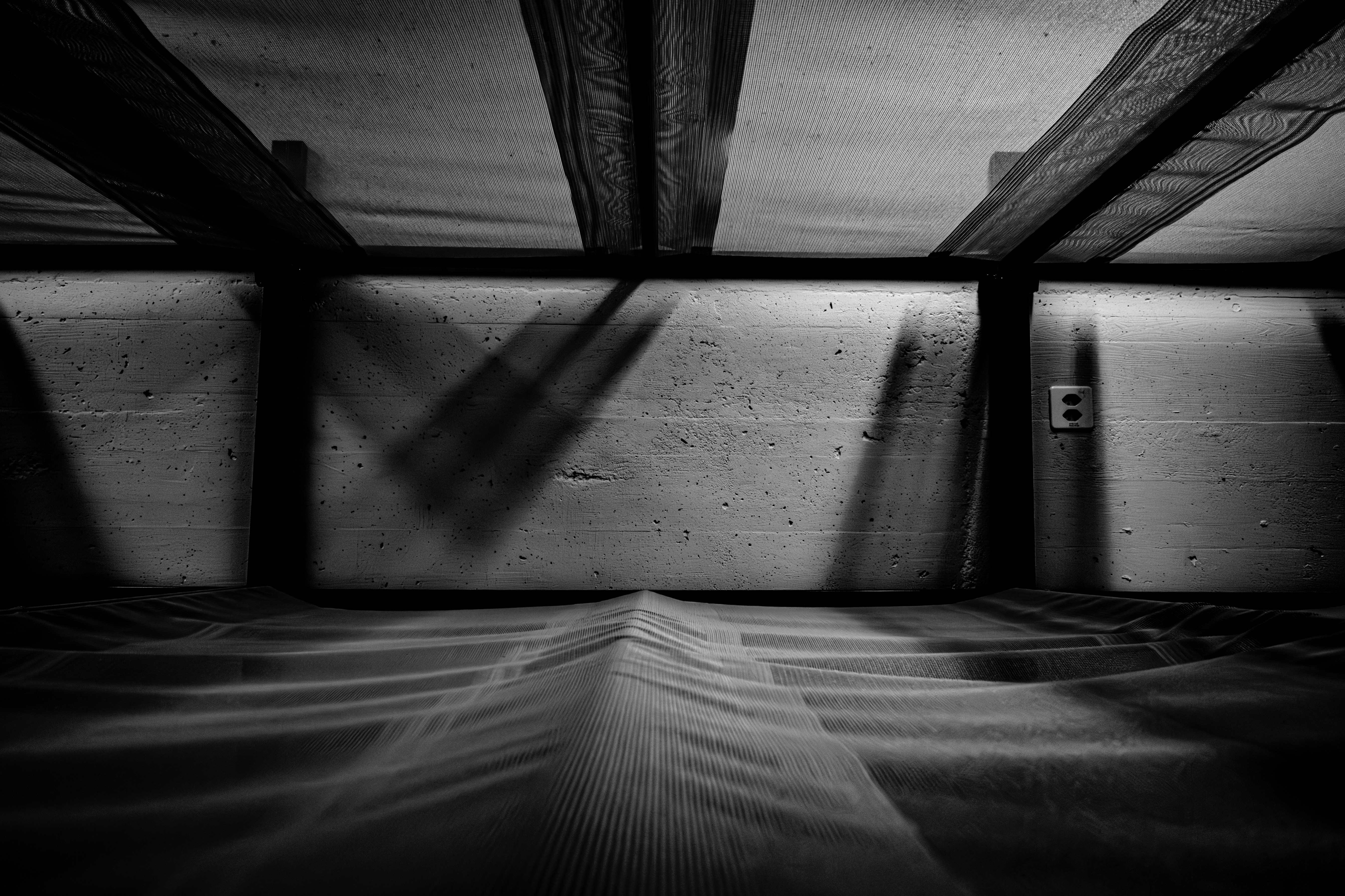 Dramatic shadows and beams in a concrete room.