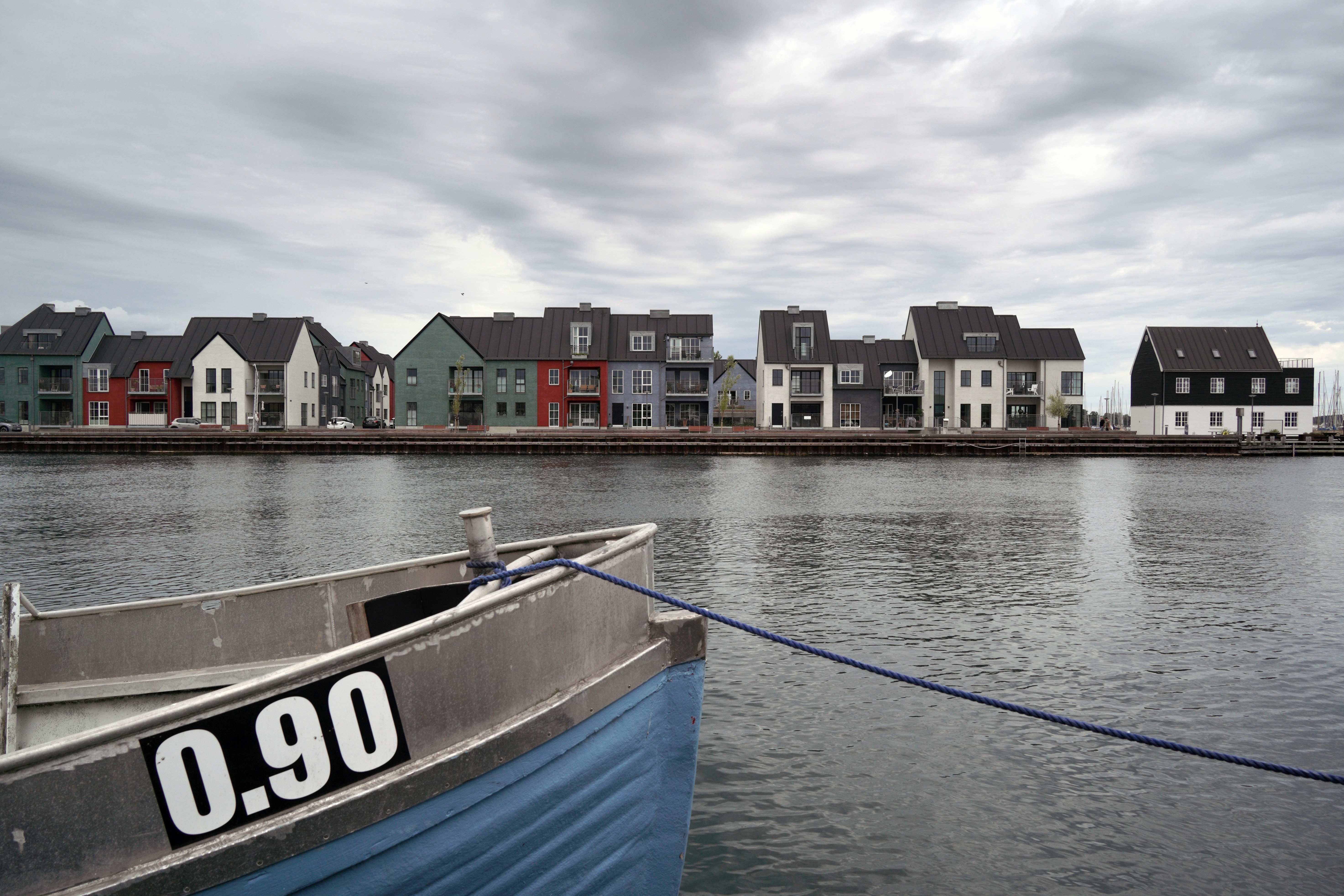 Boat moored by colorful houses on waterfront.