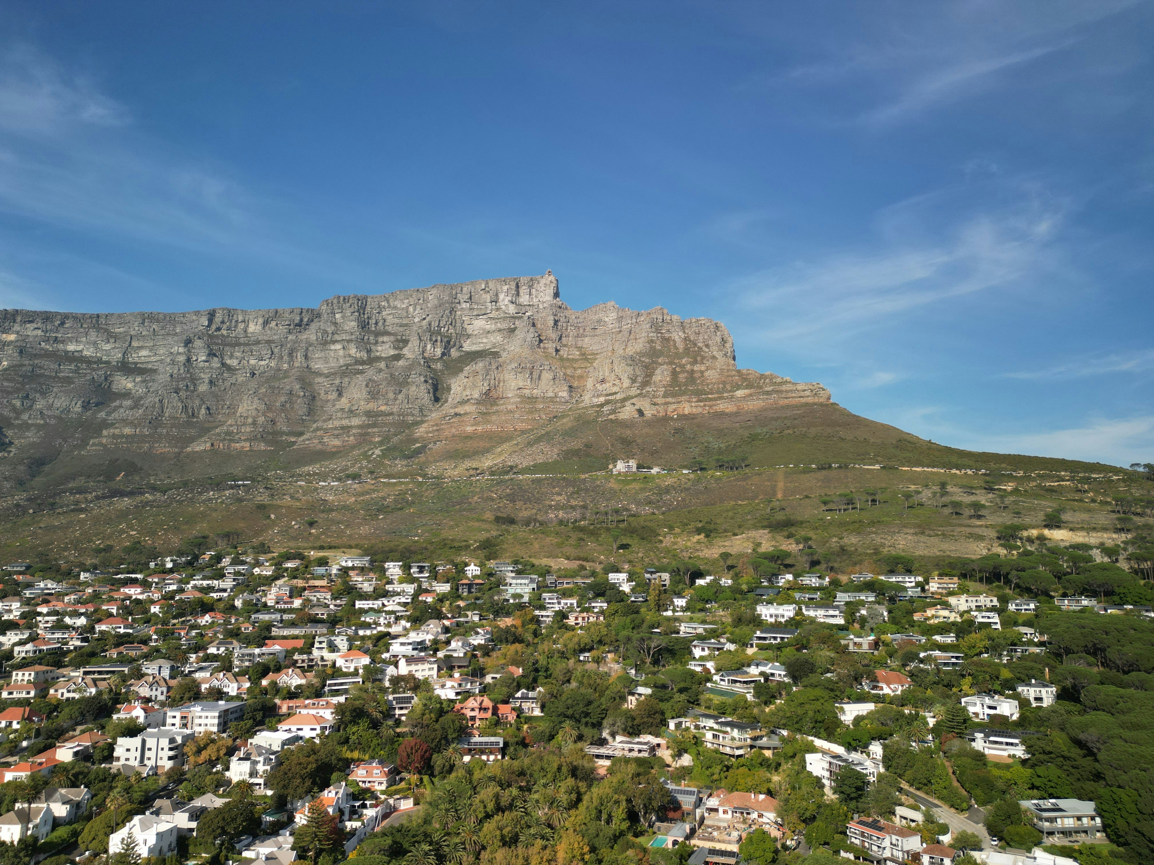 Table mountain overlooks a suburban neighborhood under a clear sky.
