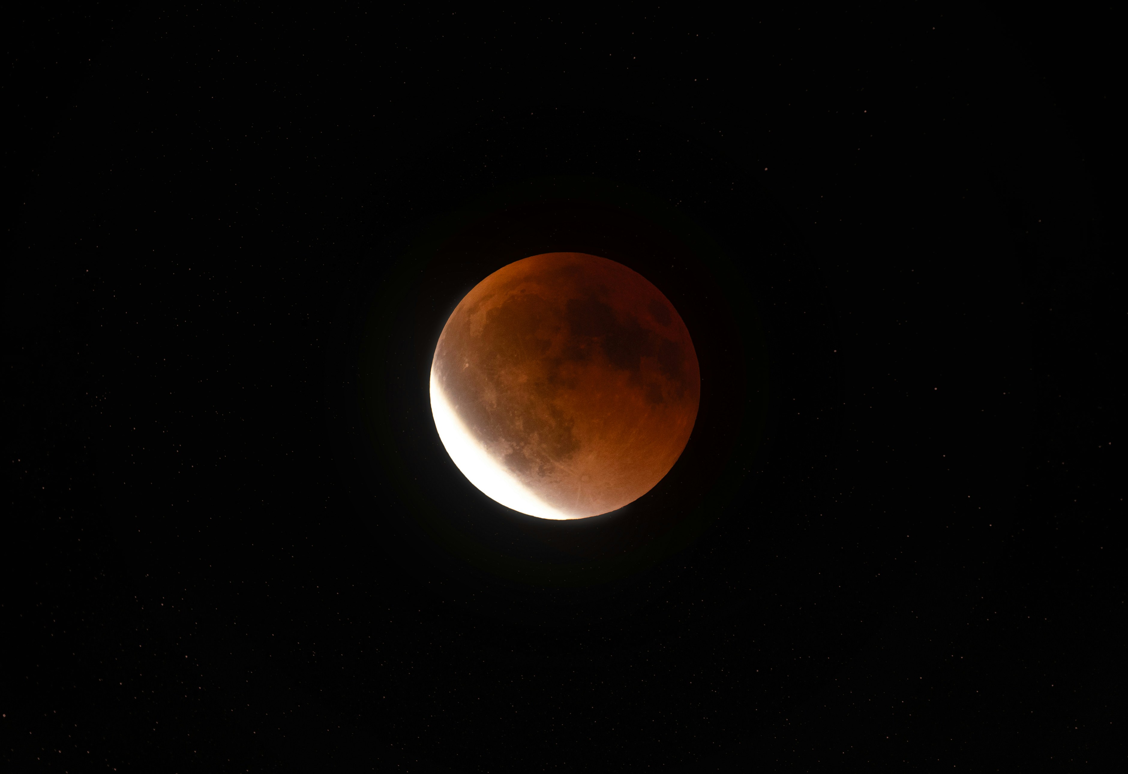 A blood moon lunar eclipse in the night sky.