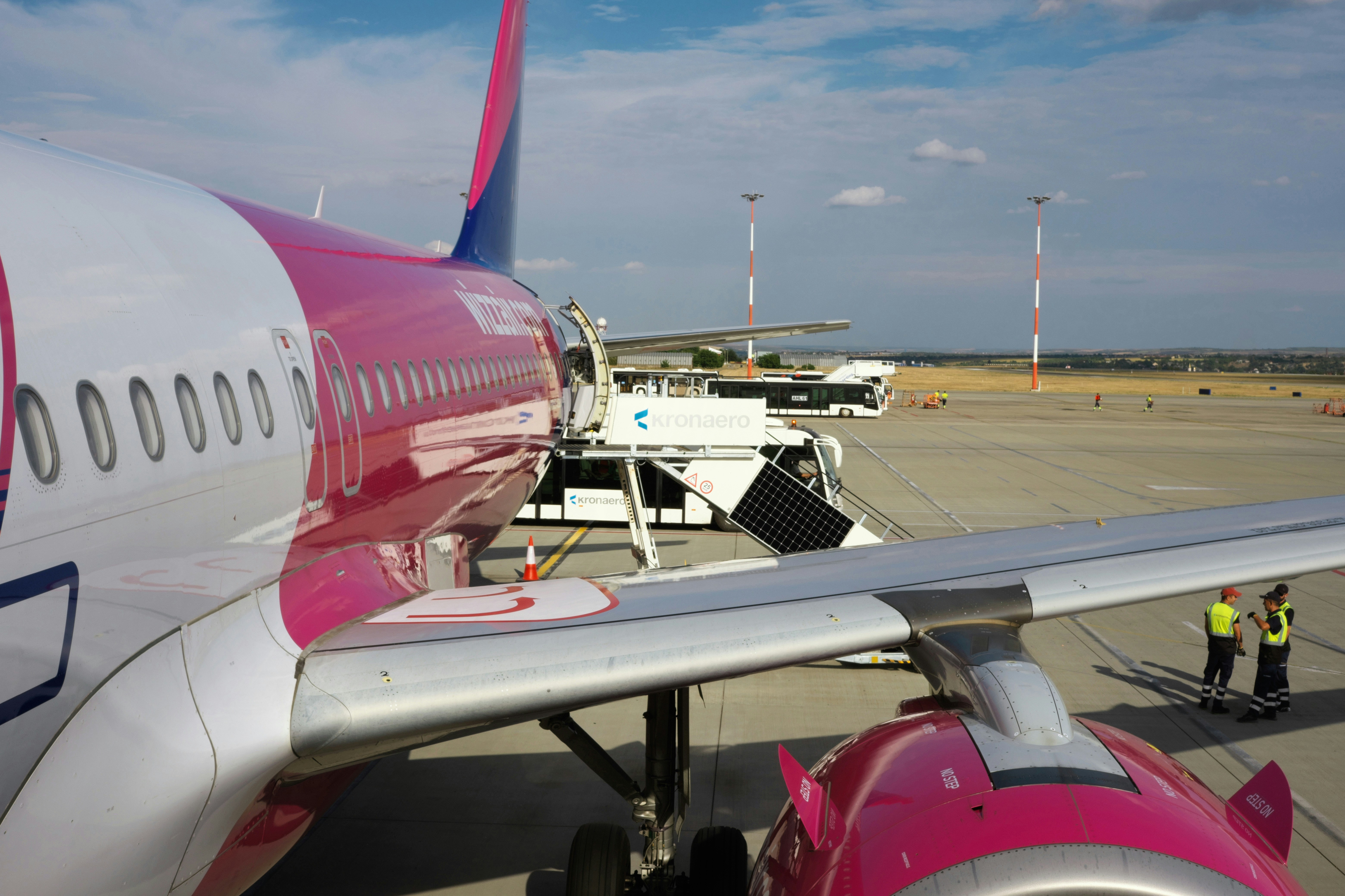 Airplane with pink livery at the airport gate