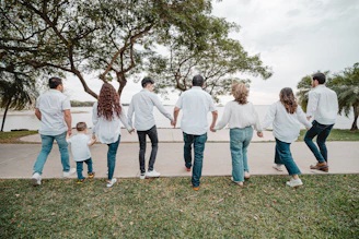 Family holding hands walking by the water