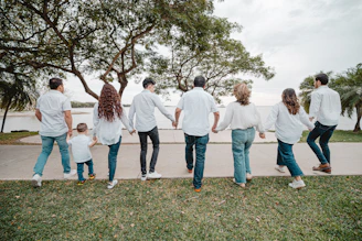 Family holding hands walking by the water