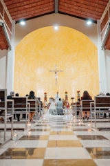 Wedding ceremony taking place at the altar in a church.