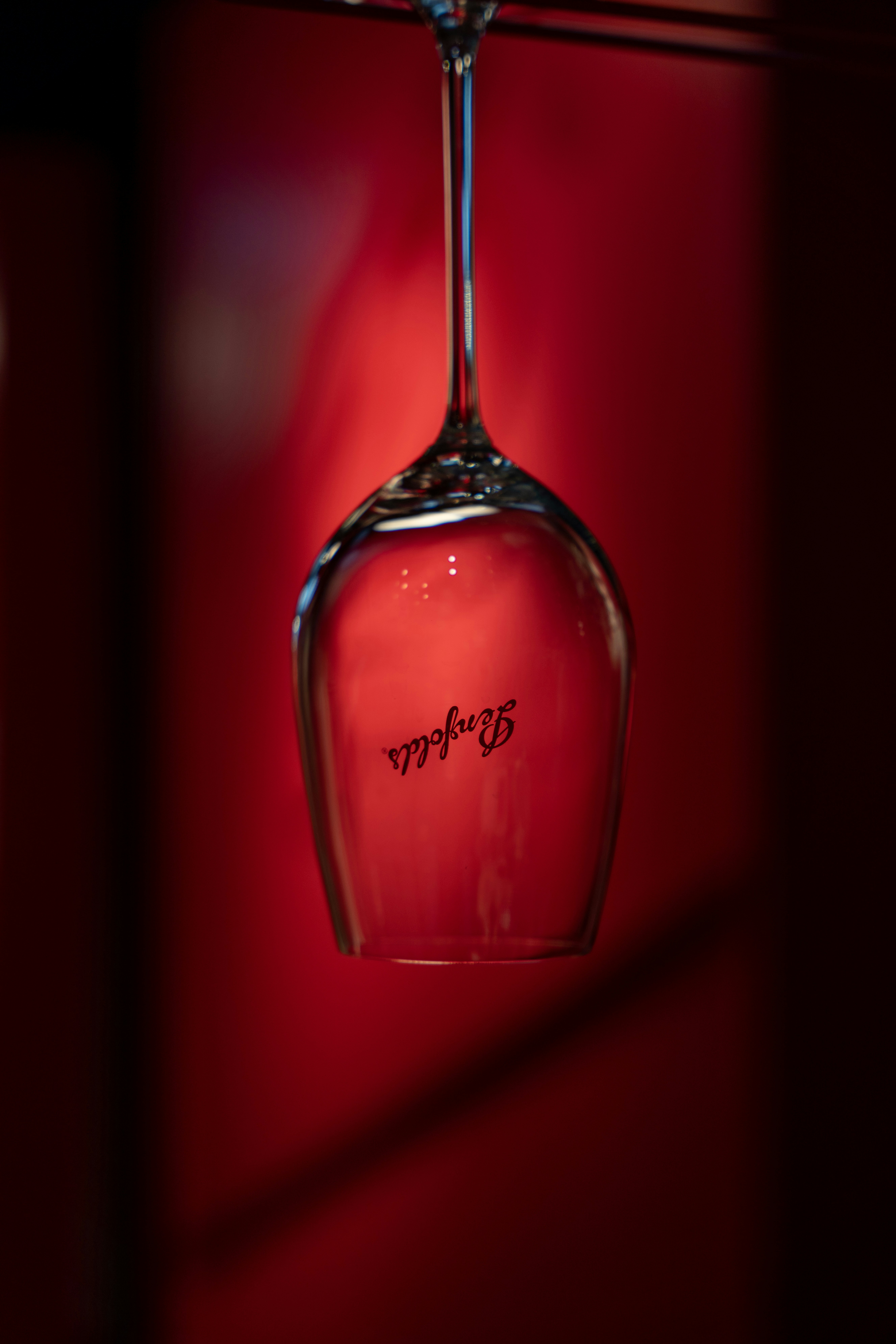 A wine glass with a logo on red background