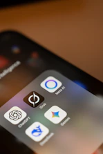 Smartphone screen displays ai app icons: chatgpt, grok, meta ai, gemini.