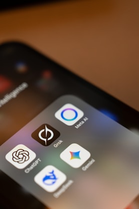 Smartphone screen displays ai app icons: chatgpt, grok, meta ai, gemini.