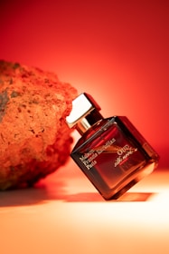 Perfume bottle next to a textured rock