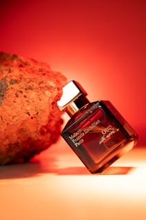 Perfume bottle next to a textured rock