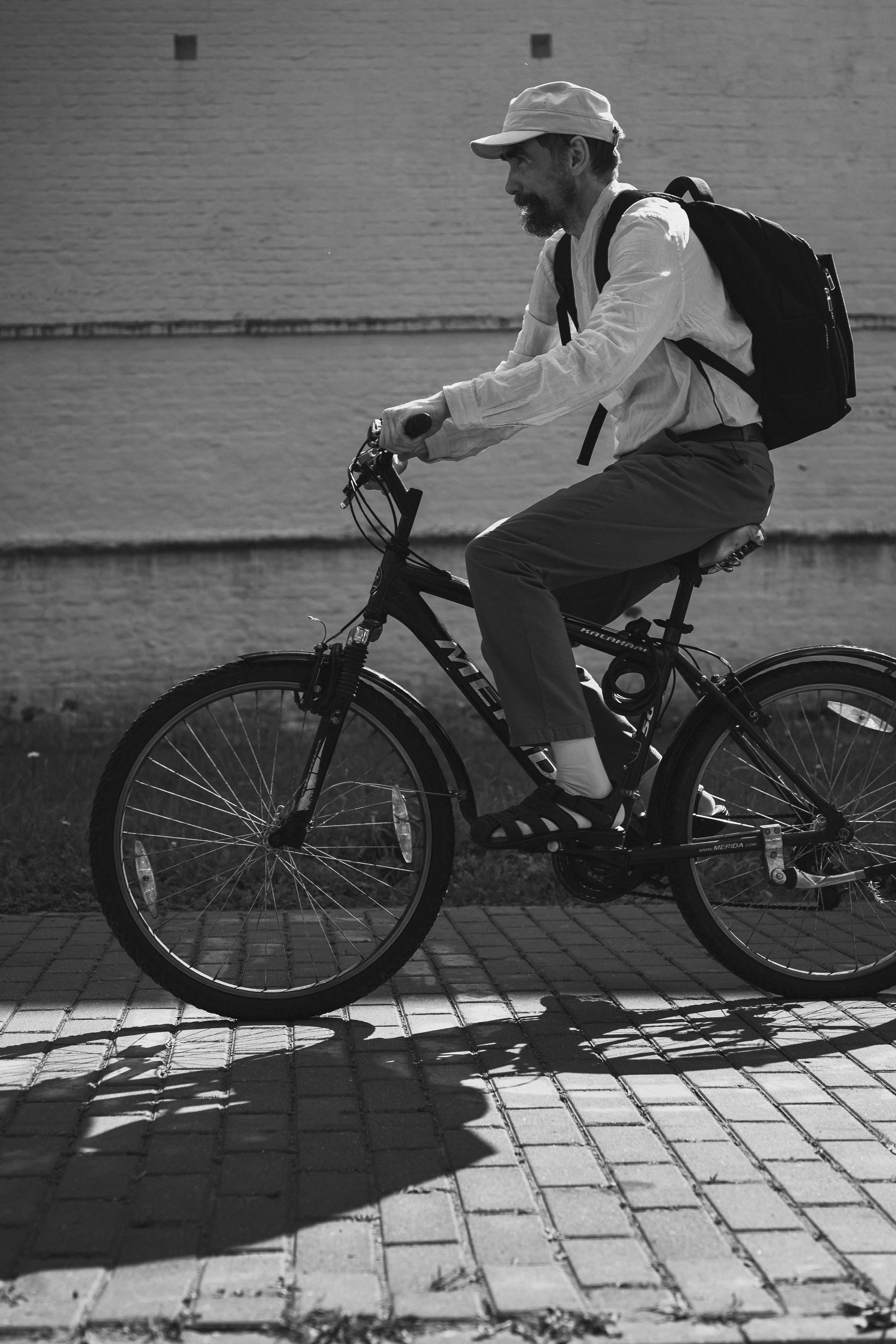 Man rides a bicycle on a brick path.