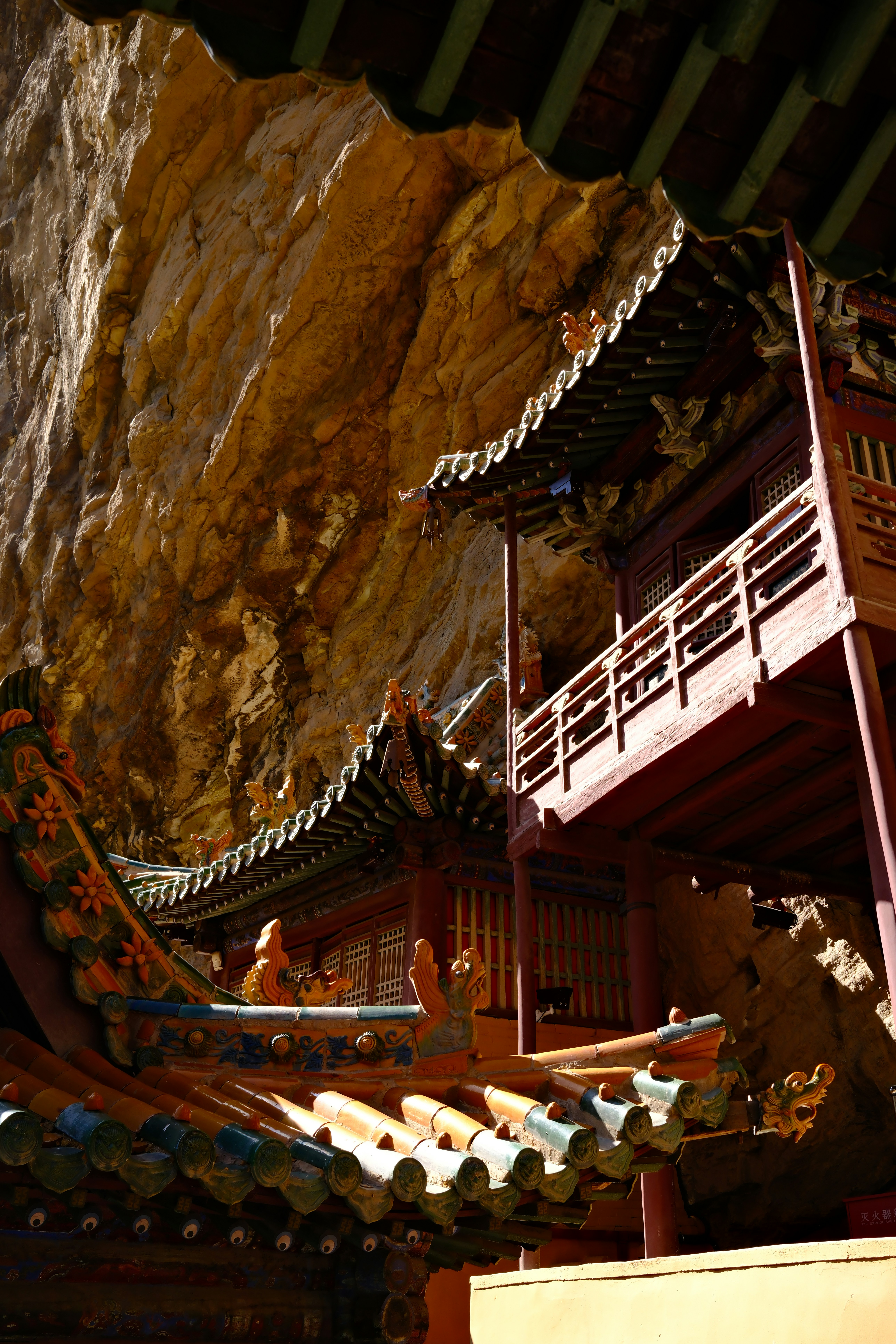 Traditioneller chinesischer Tempel, der in eine felsige Felswand gebaut wurde.