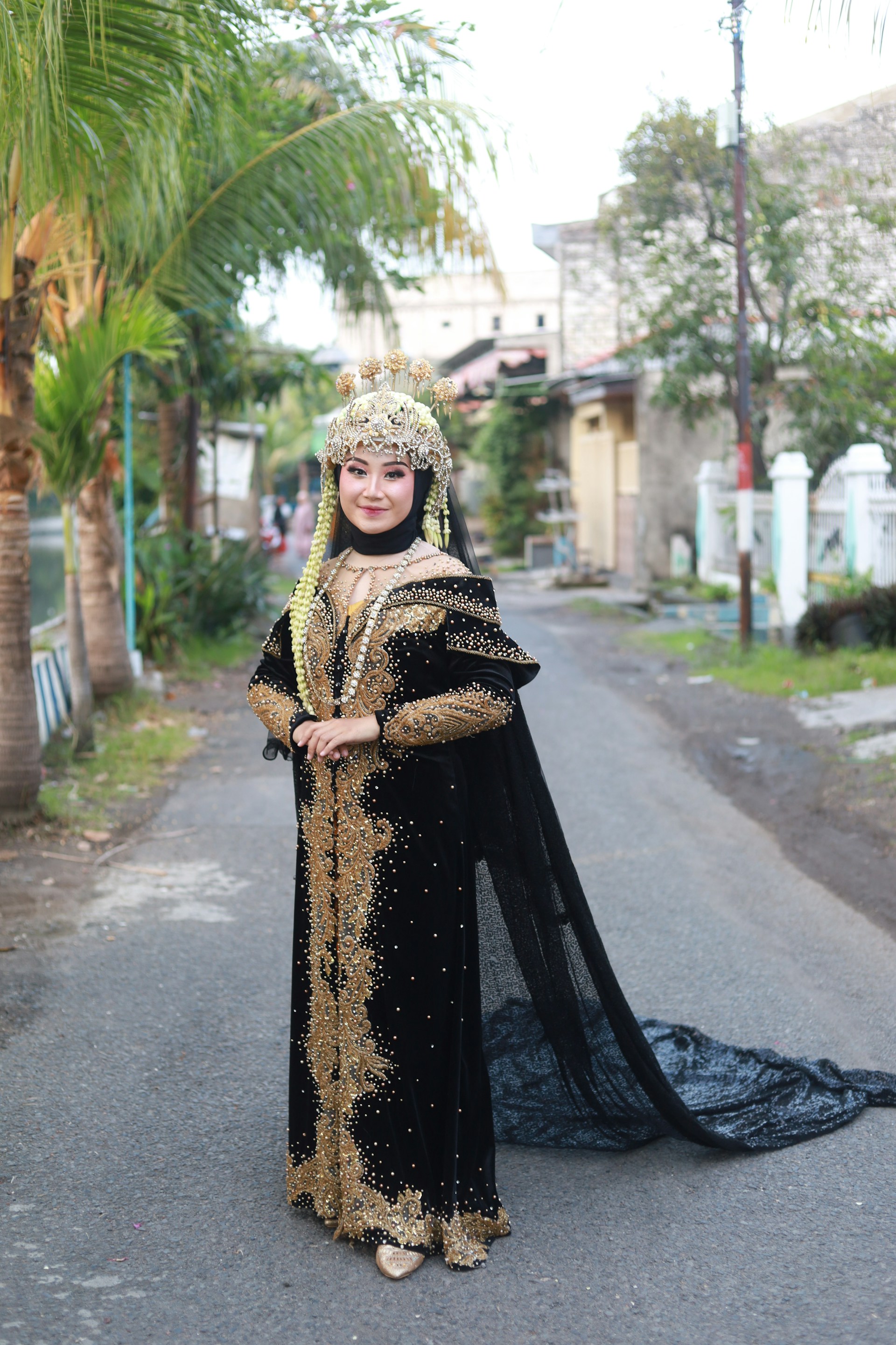 Woman in traditional black and gold attire with veil