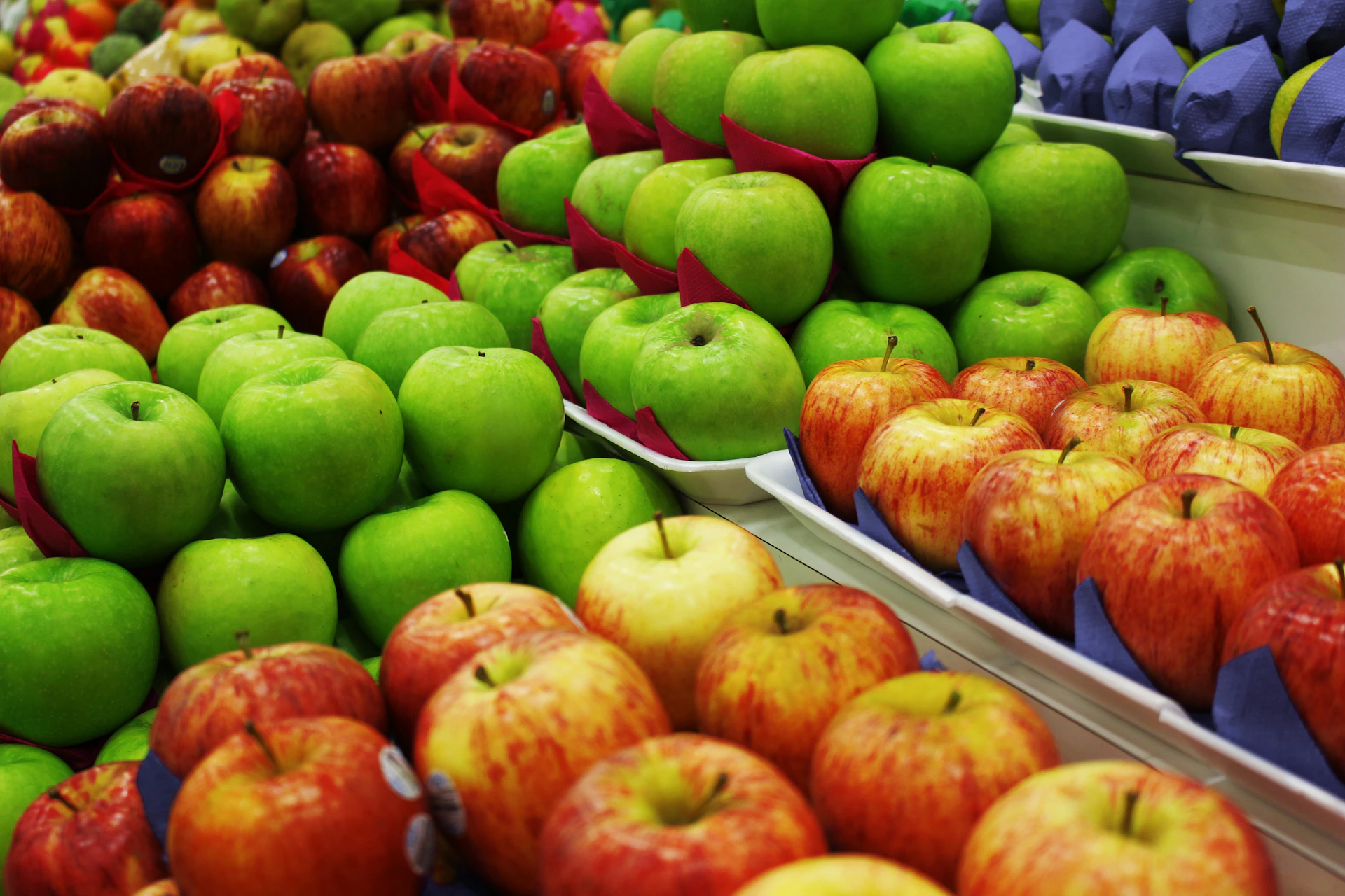 Fresh apples displayed in rows at a market.