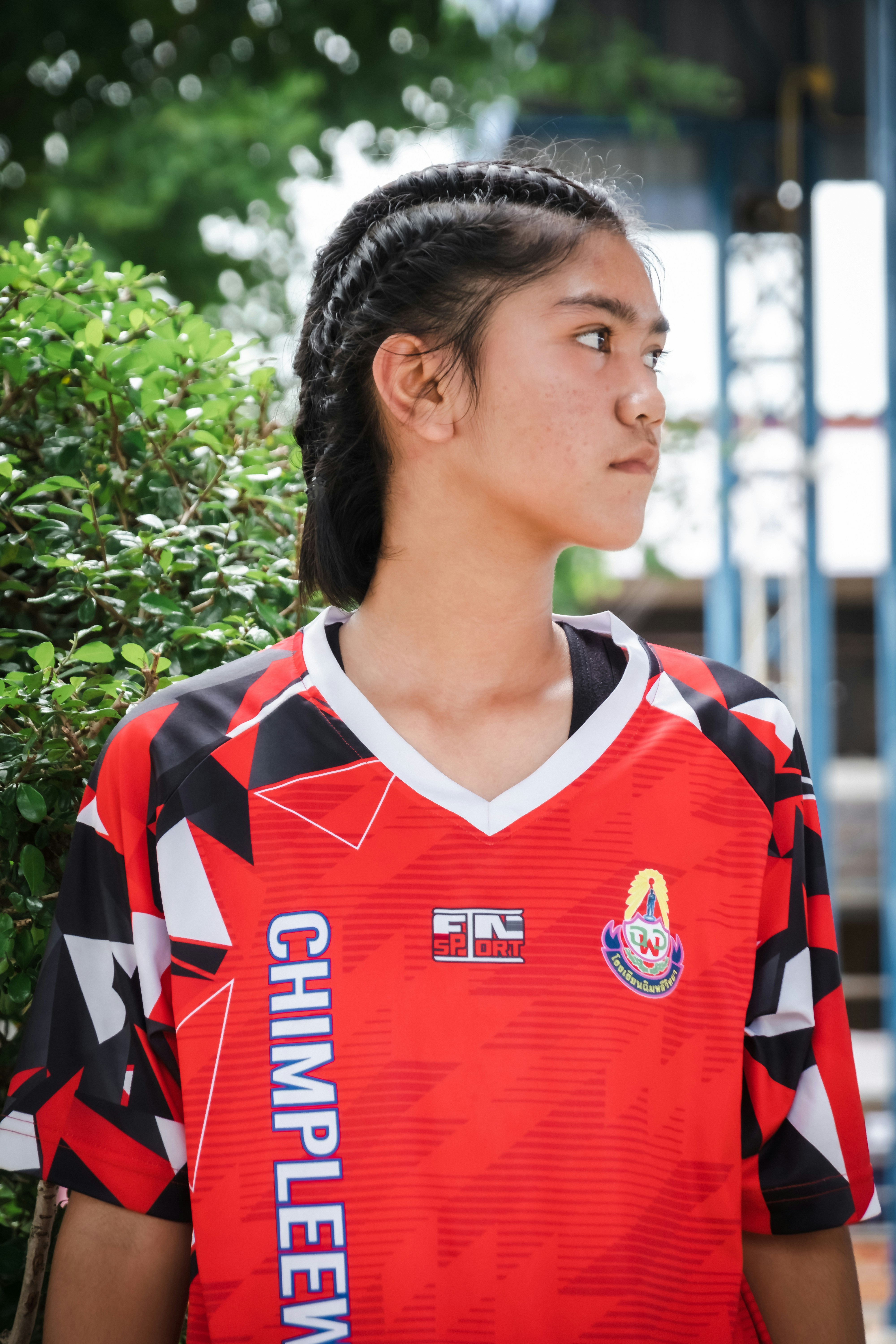 Wanita muda dengan kemeja atletik merah di luar ruangan