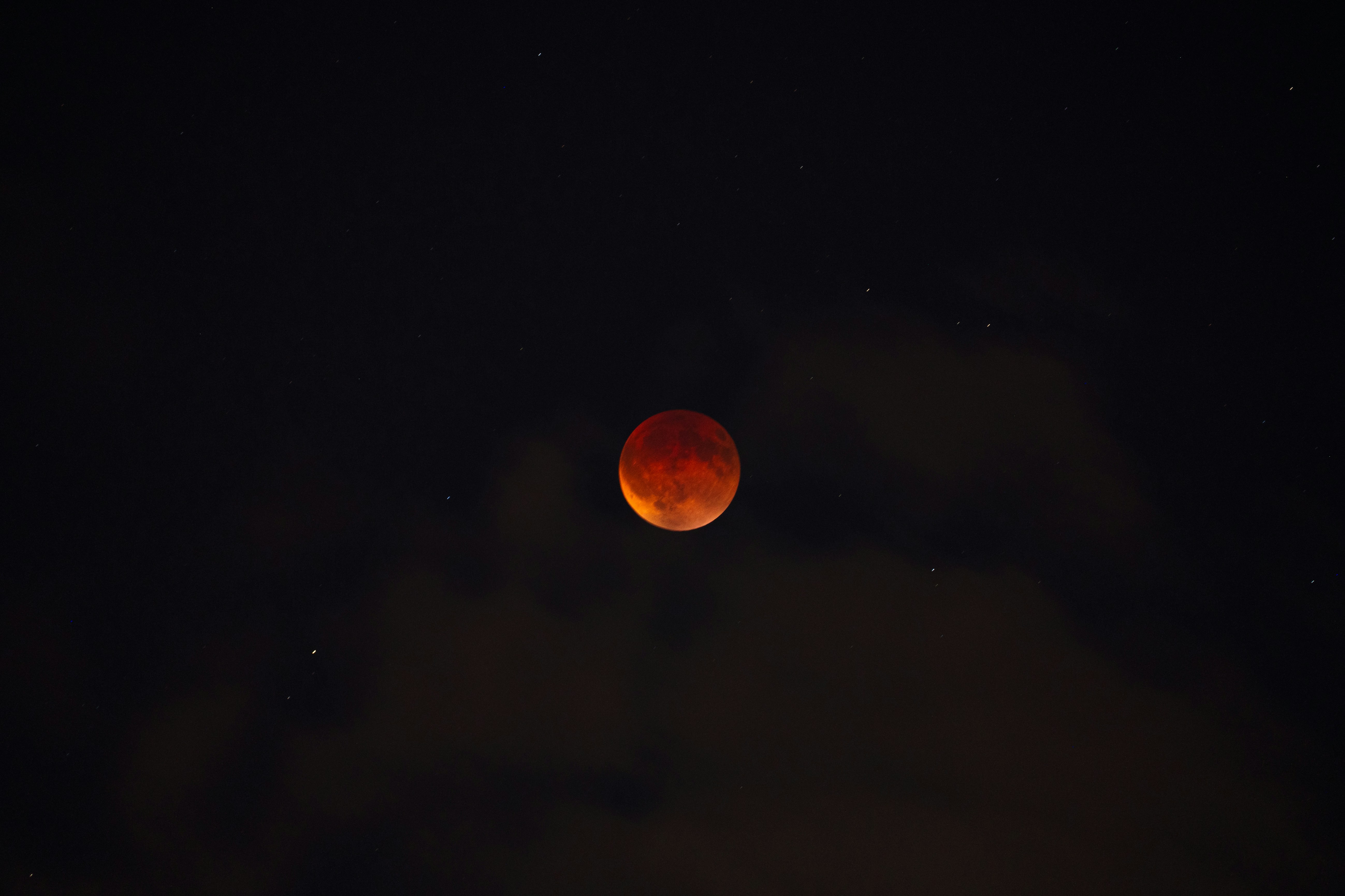 Blood moon eclipsed in a starry night sky