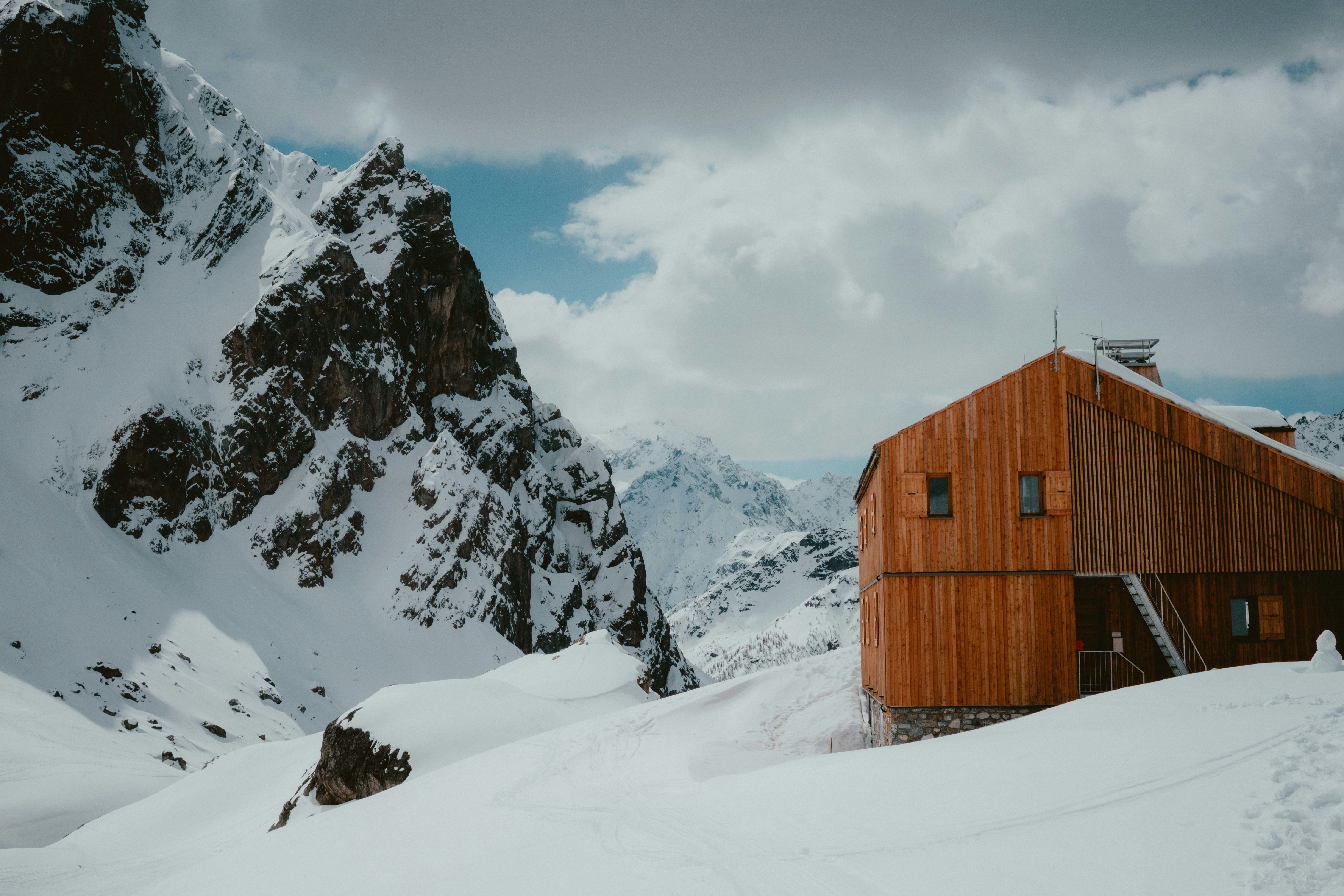 Cabaña de madera enclavada en un paisaje montañoso nevado