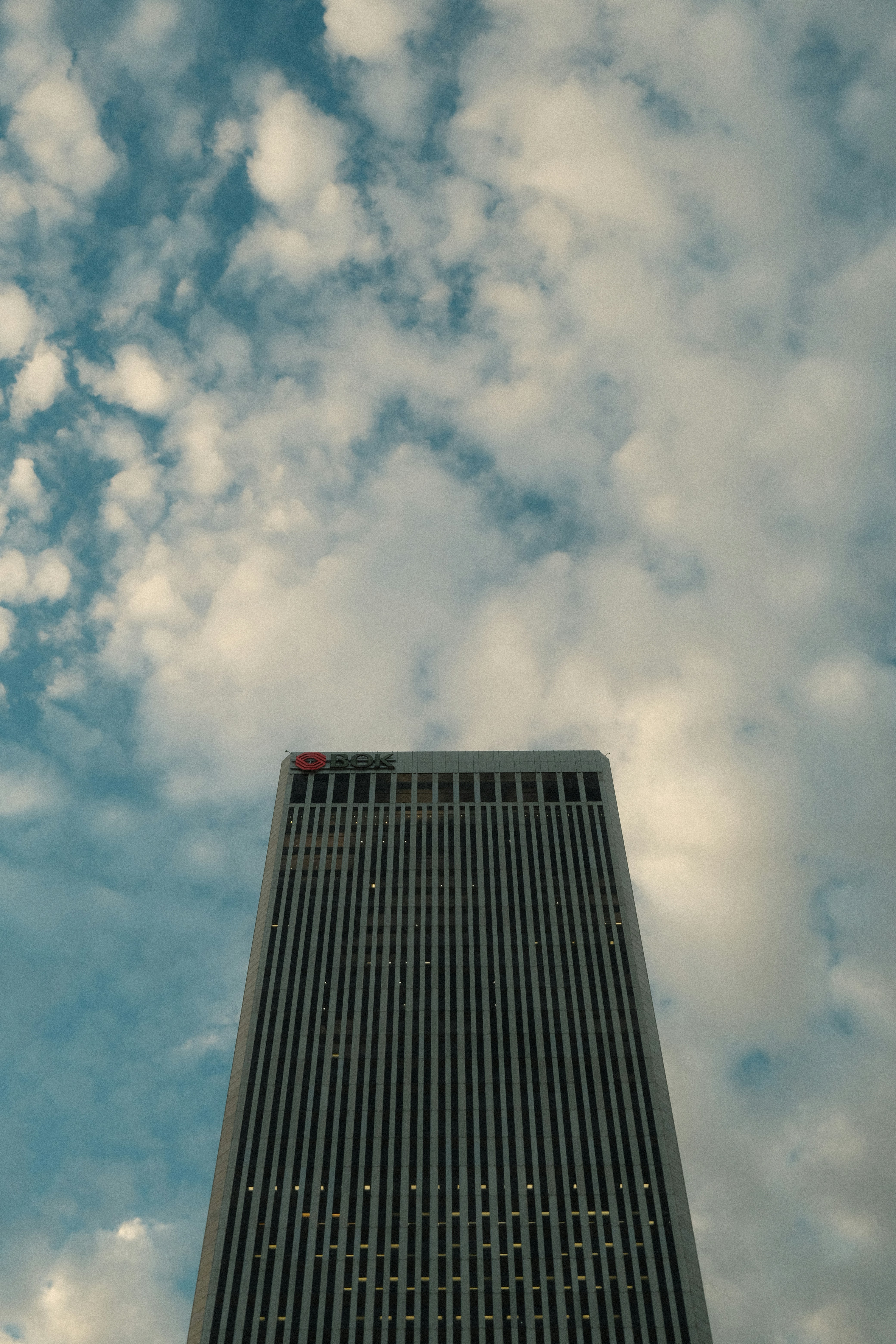 Modern skyscraper against a cloudy blue sky
