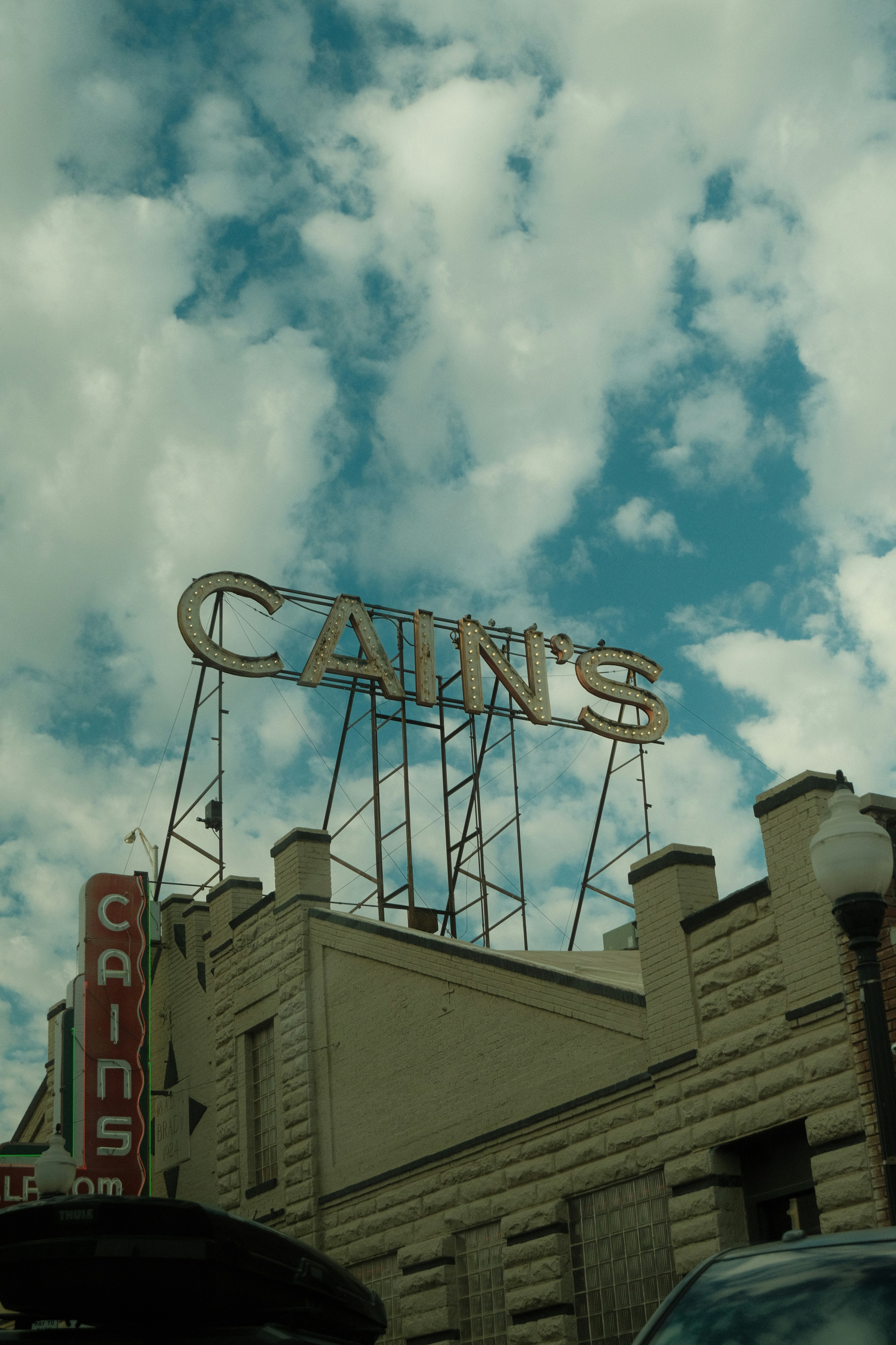 Cain's sign illuminated against a cloudy sky