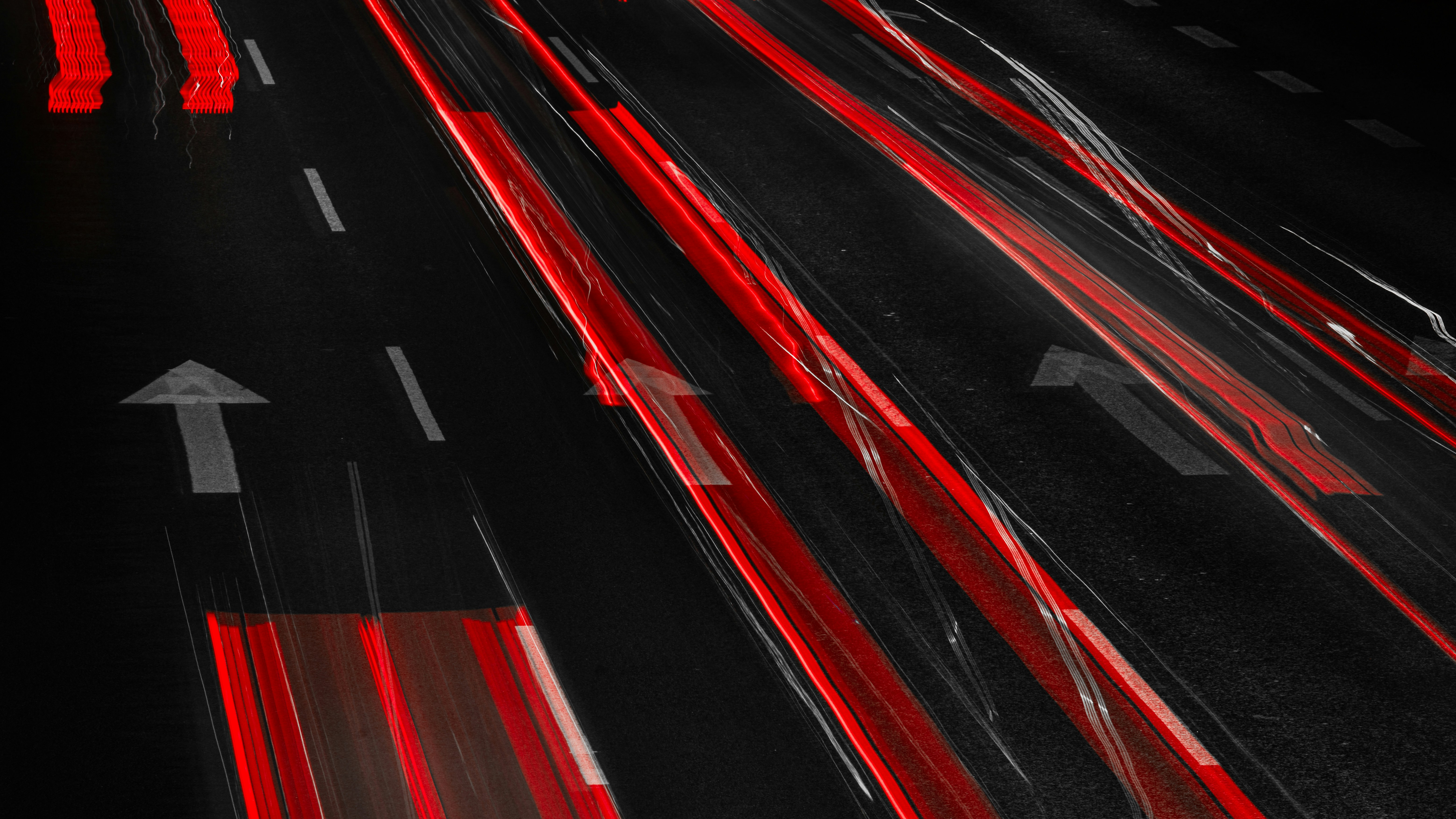 Rote Lichter auf einer dunklen Straße bei Nacht.