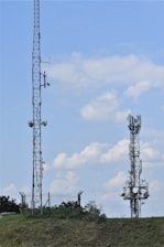 Two tall communication towers against a blue sky.