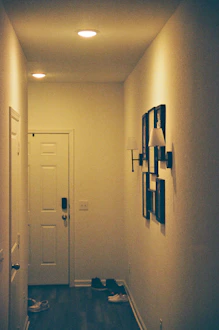 Hallway with framed art and shoes on floor