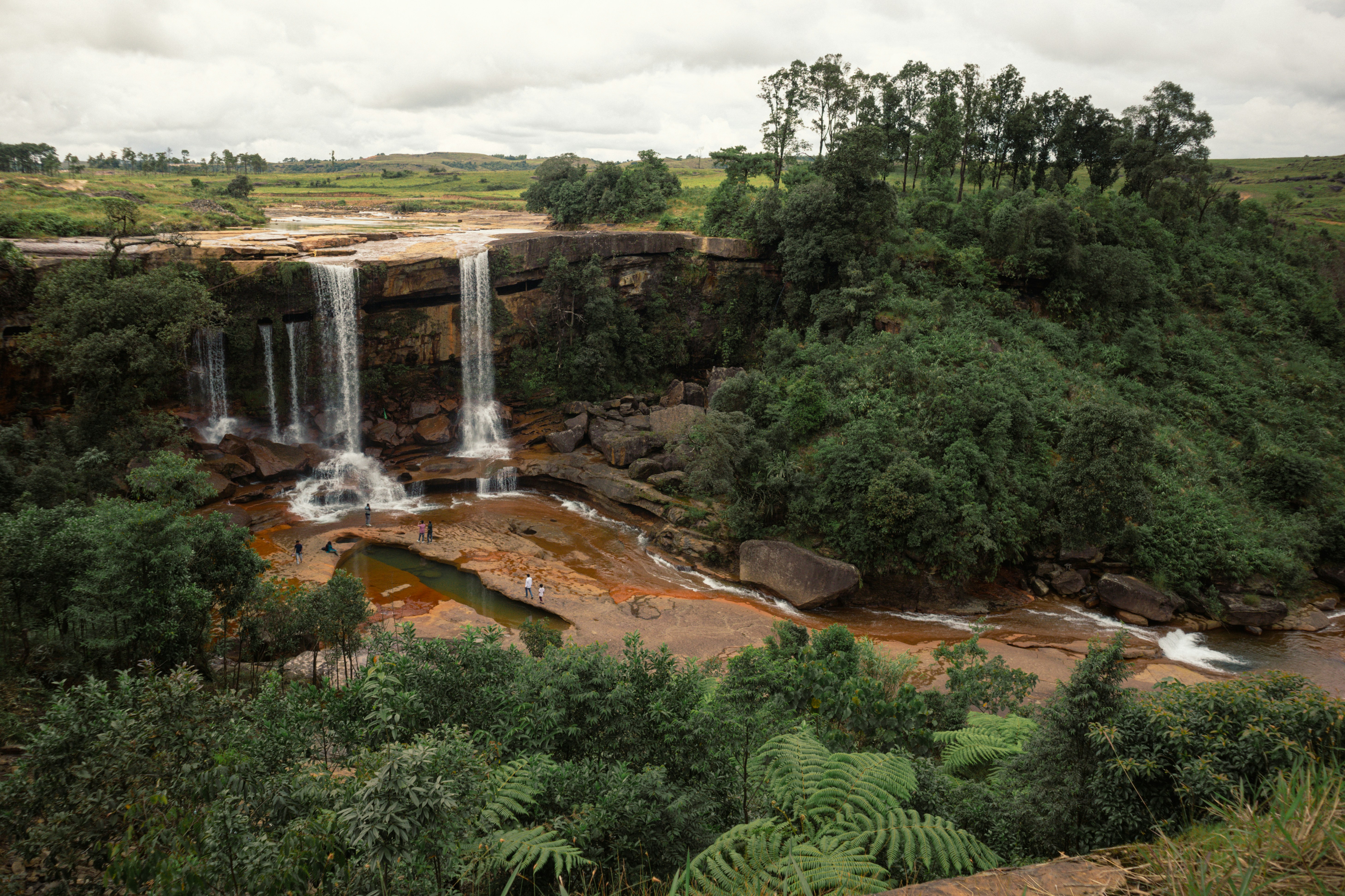 A scenic waterfall cascading over rocks surrounded by lush greenery