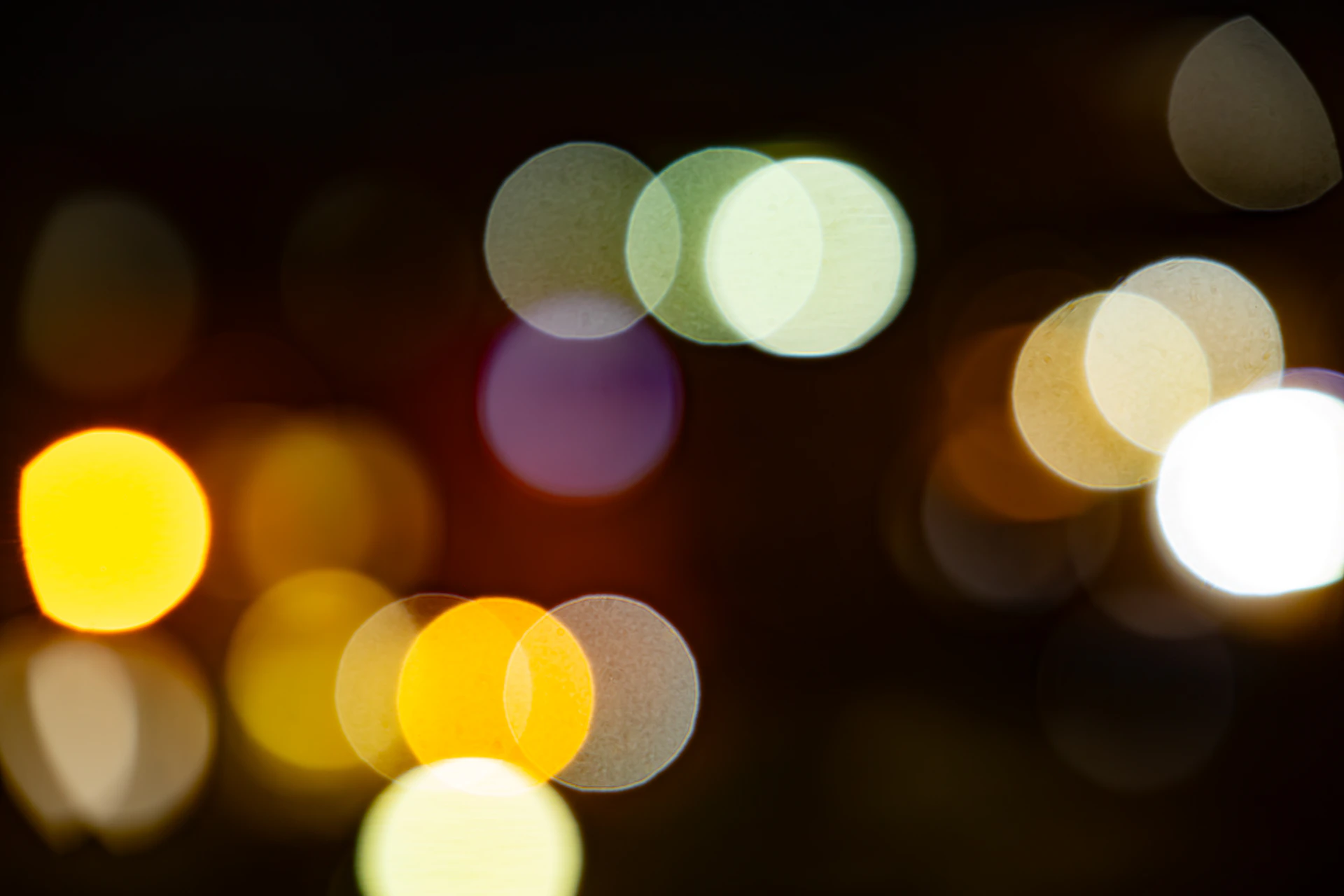 Abstract bokeh lights in yellow, white, and purple.