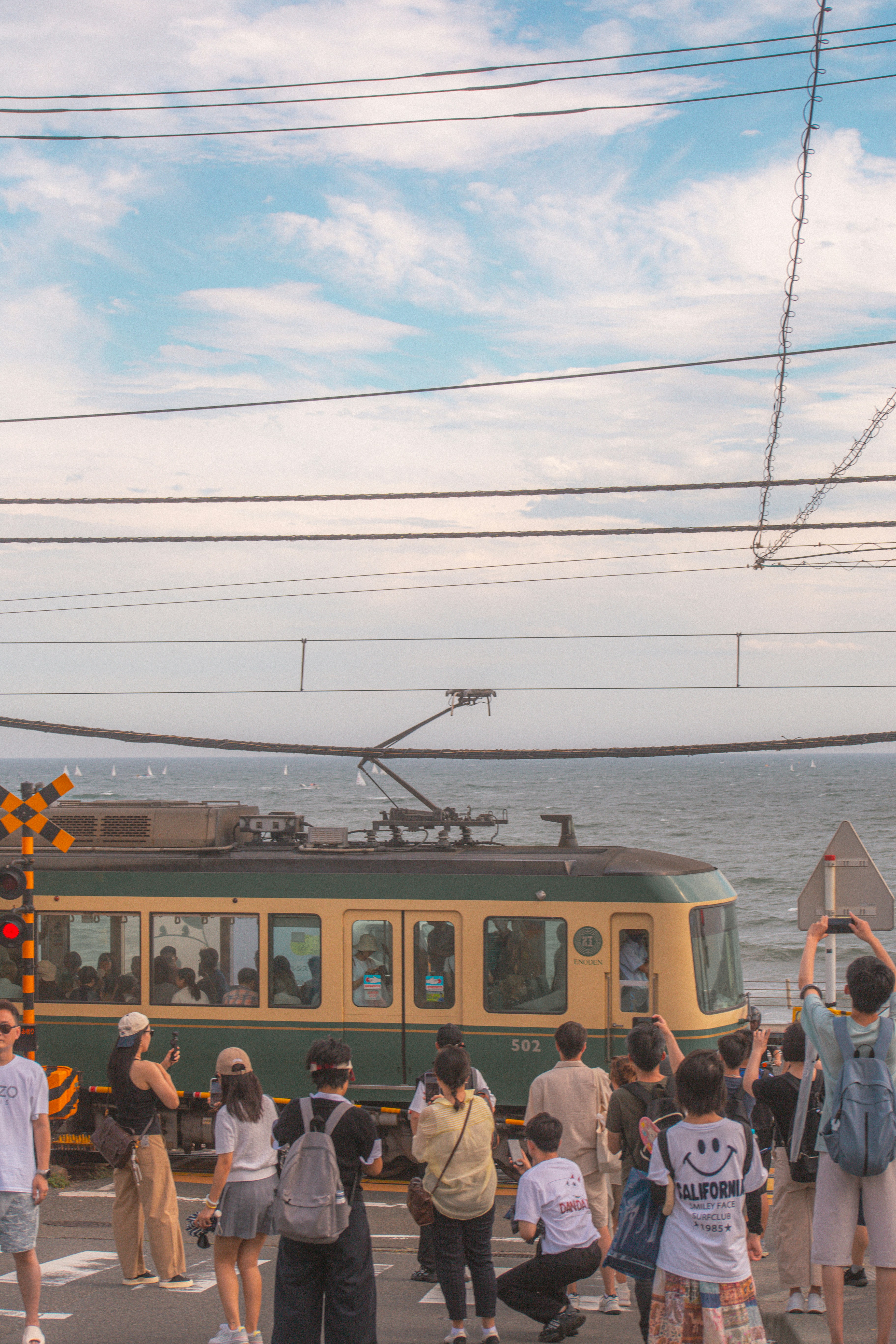 People watch a train pass by the ocean