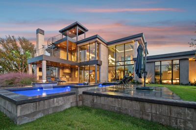 Modern luxury home with swimming pools at dusk
