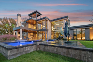 Modern luxury home with swimming pools at dusk