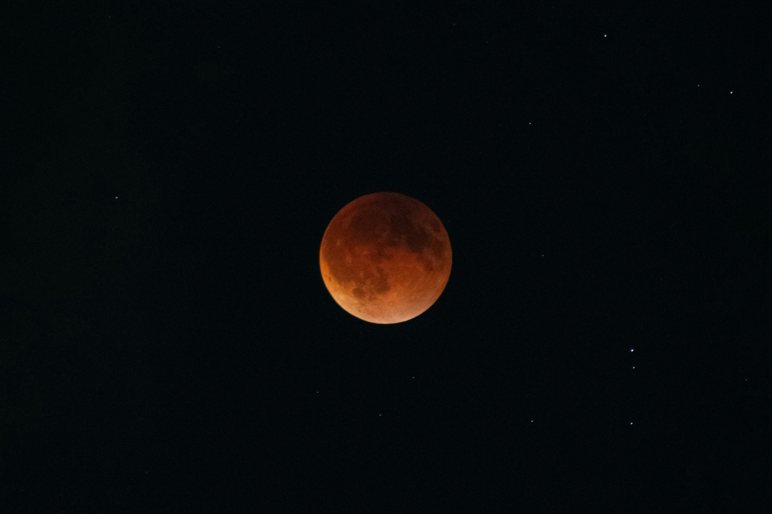 Blood moon during a lunar eclipse in starry sky
