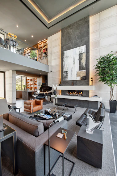 Luxurious modern living room with grand piano and fireplace.