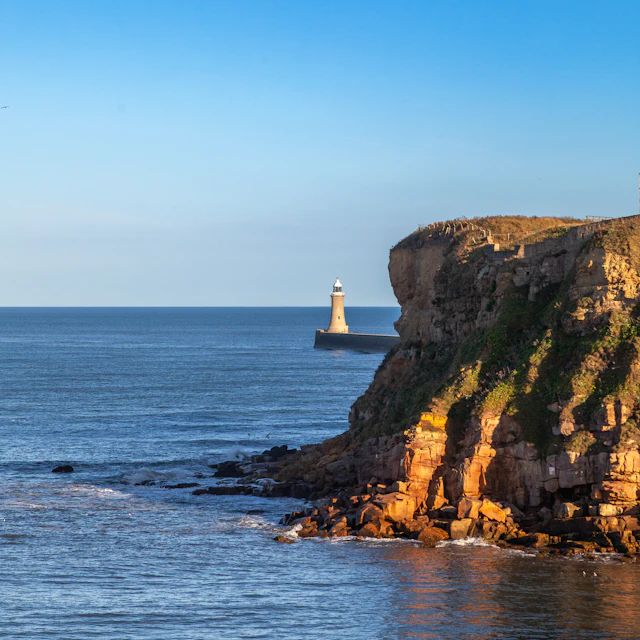 A lighthouse on a rocky cliff by the sea