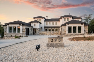 Modern luxury home with stone accents at sunset.