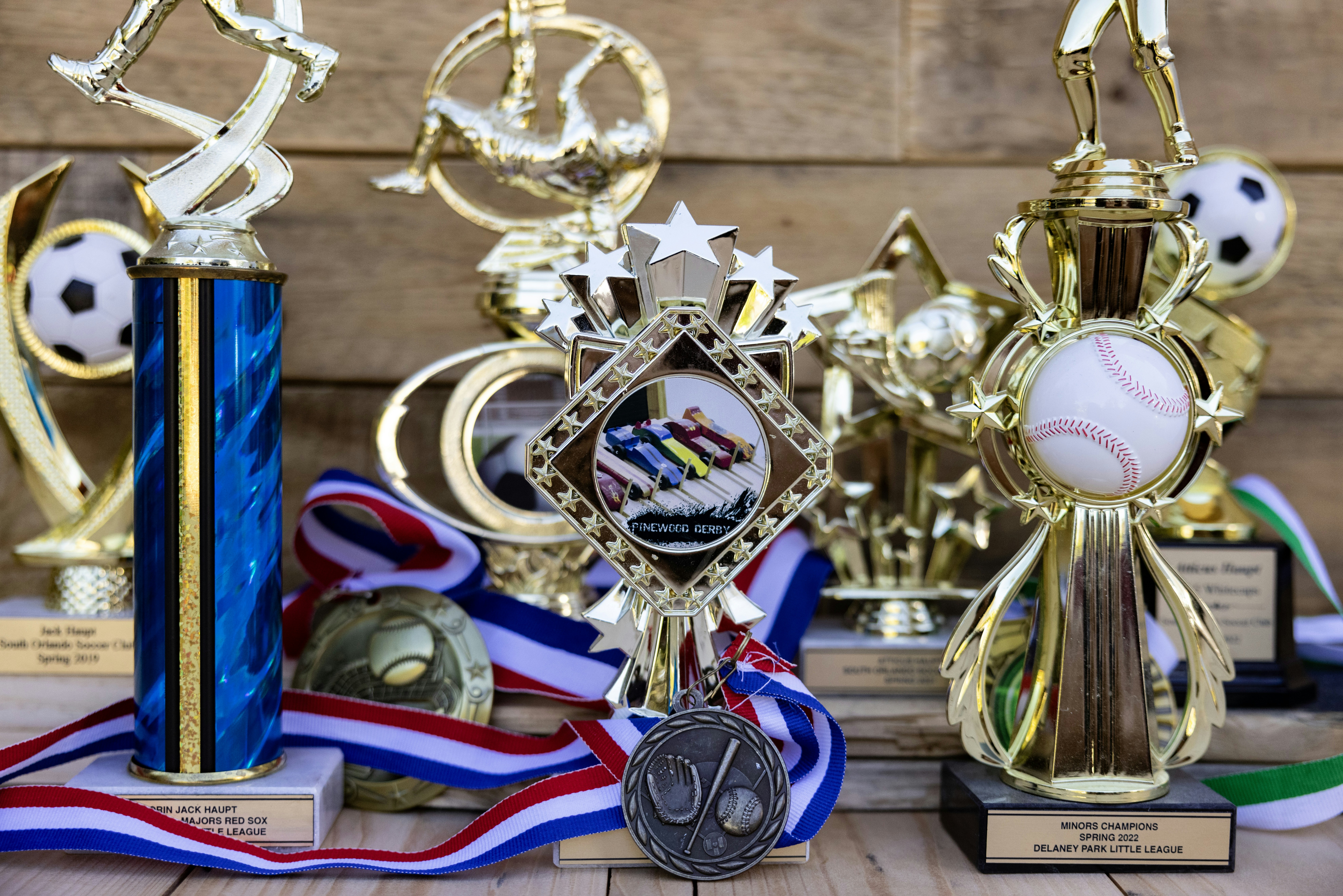 Collection of sports trophies and medals on wooden background