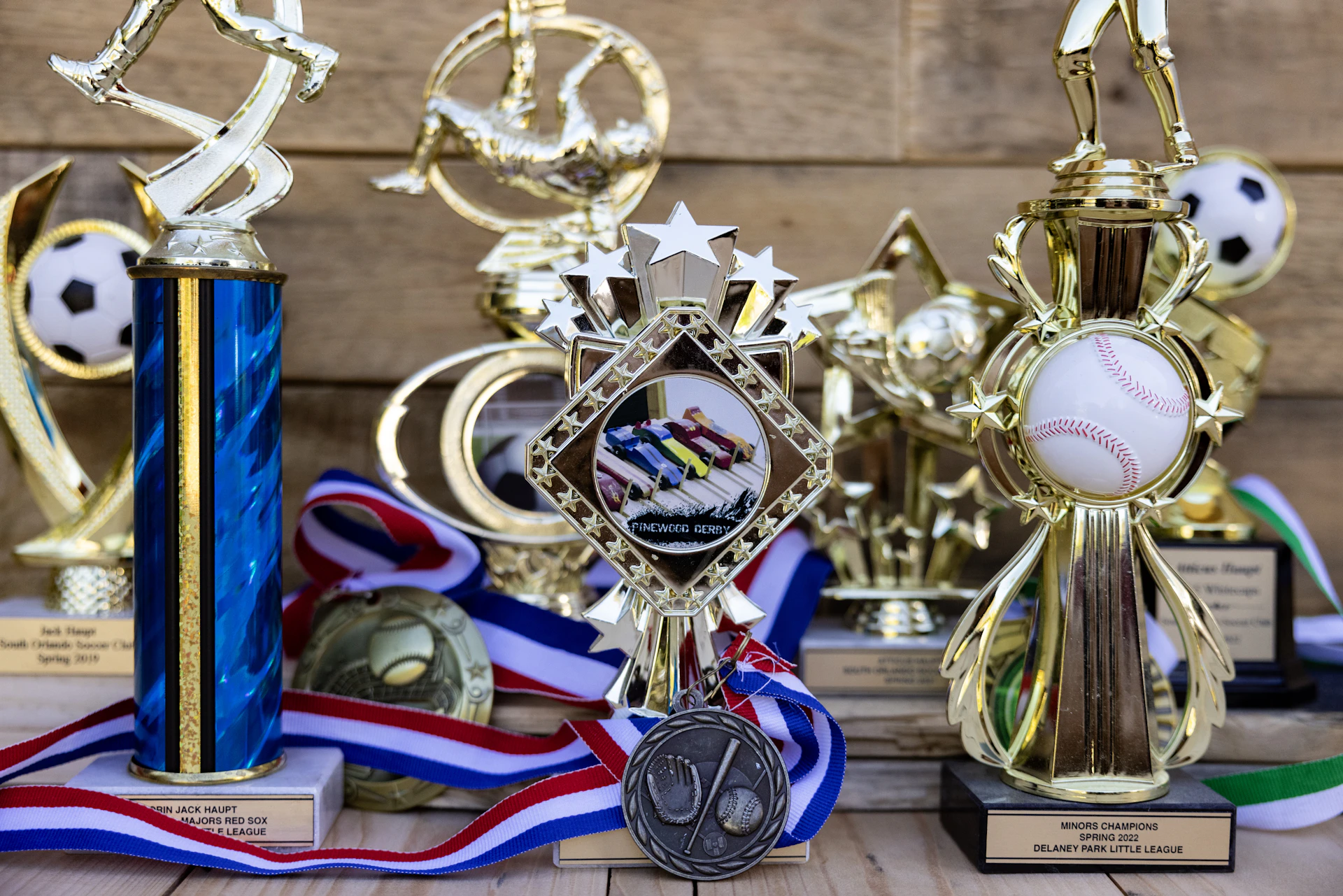 Collection of sports trophies and medals on wooden background
