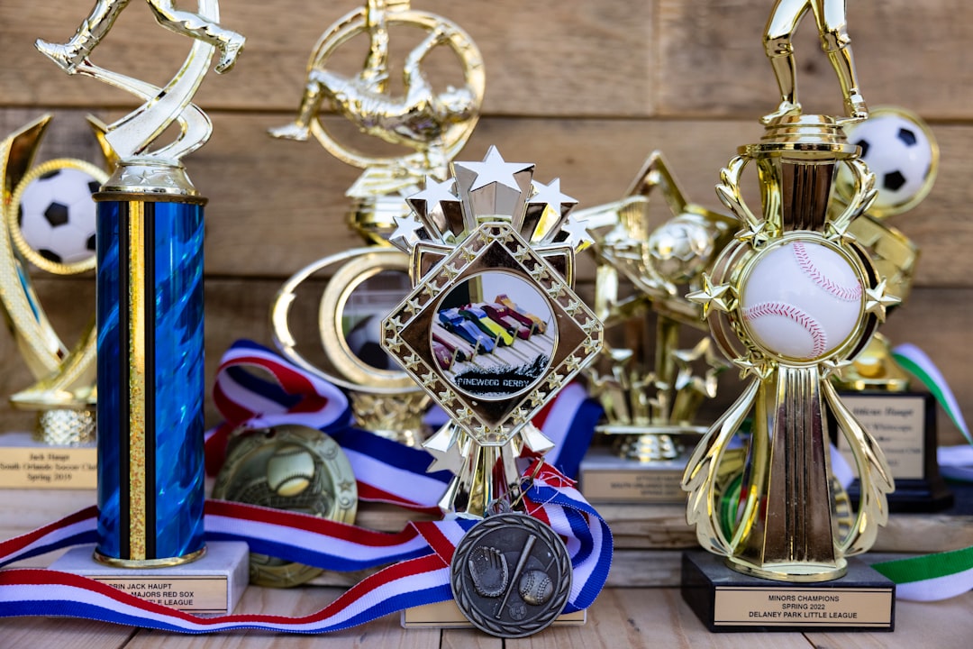 Collection of sports trophies and medals on wooden background
